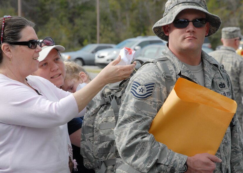 Tech Sgt. David Smith, 728th Air Control Squadron and 17-year veteran, has his literally hand-made luggage tags adjusted prior to his deployment March 11 at Eglin Air Force Base, Fla.  The luggage tags have the hand prints of his three children on them to accompany him on his 11th deployment.  He has deployed five times with the 728th.  The 728th sent almost half their squadron in support of Operation Iraqi Freedom, some of whom had just returned from deployment in September.  (U.S. Air Force photo/Samuel King Jr.)