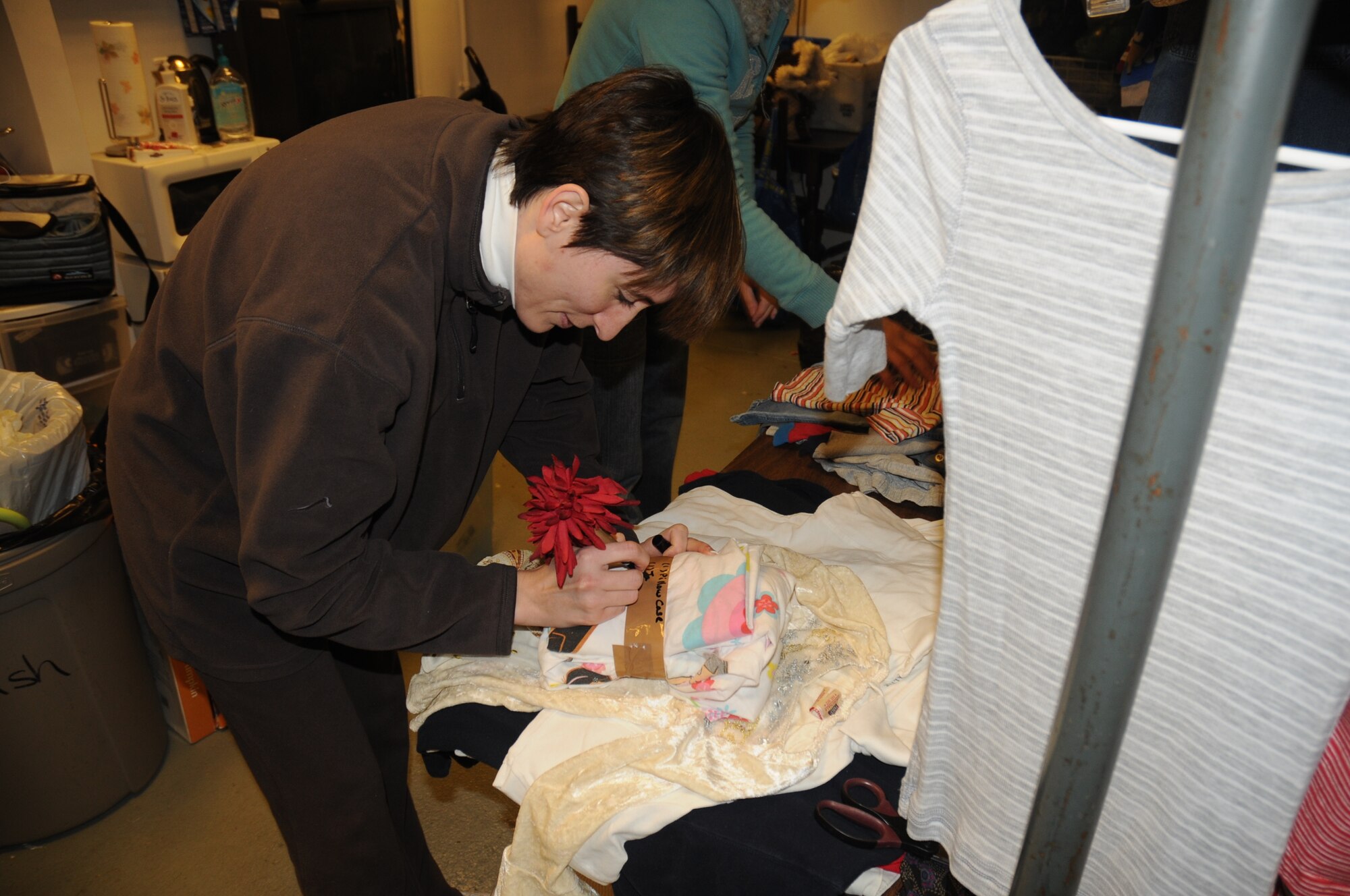 Christie Finney, wife of TSgt Daniel Finney, RAF Feltwell Airman Leadership School instructor, labels donated goods while volunteering at the RAF Lakenheath Airman’s Attic Feb. 25. (U.S. Air Force by 2nd Lt. Ashley Skillman)