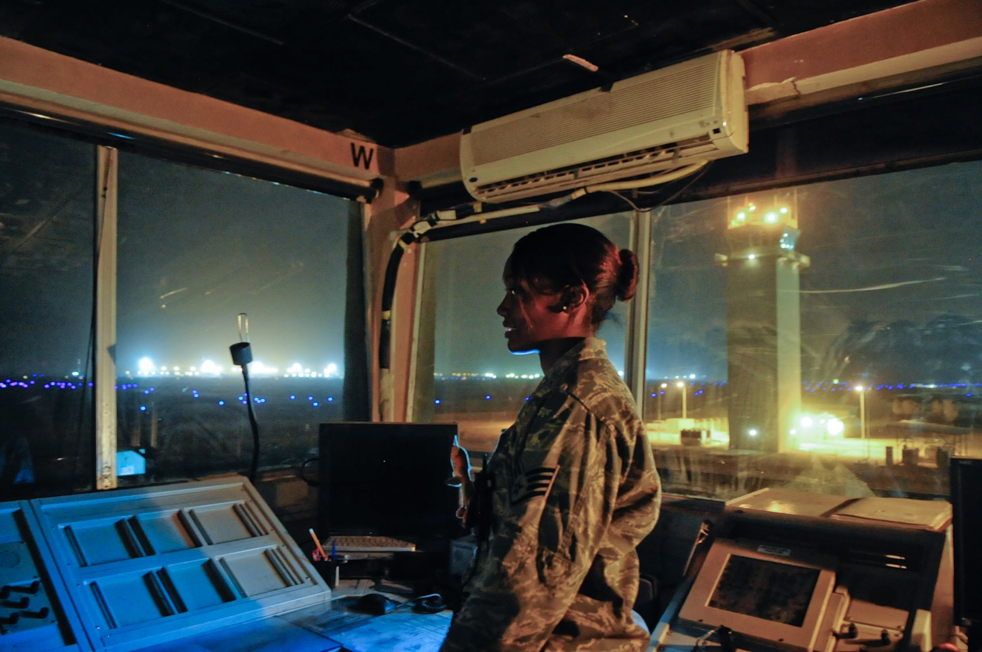 U.S. Air Force Staff Sgt. Madonna Moffatte, 407 Expeditionary Operations
Support Squadron, deployed from 35th Operational Support Squadron, Davis
Mothen, Ariz., air traffic controller, sends her last transmission from the
old tower as the new air traffic control tower in the background  becomes
operational shortly after midnight March 12, 2010 at Ali Base, Iraq.  The
ATC tower marks the beginning of a new era of modernization here at Ali
Base. (U.S. Air Force Photo by Senior Master Sgt. Elizabeth
Gilbert/released)
