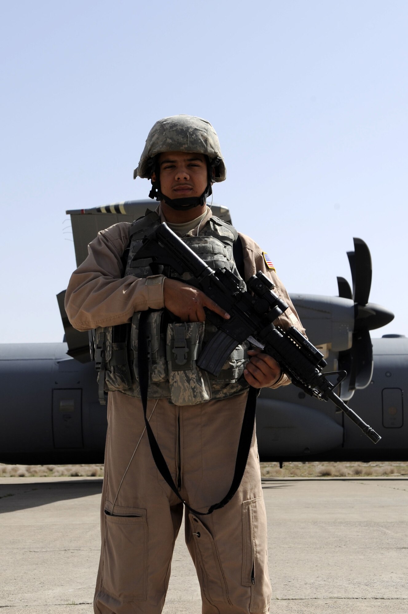 Airman 1st Class Sean Padilla, 451st Expeditionary Security Forces Squadron fly away security team, provides ground security for a C-130J March 12 at Shindan, Afghanistan.  Airman Padilla is assigned to the 49th Security Forces Squadron in Holloman AFB, NM.  (U.S. Air Force photo by Senior Airman Nancy Hooks/Released)