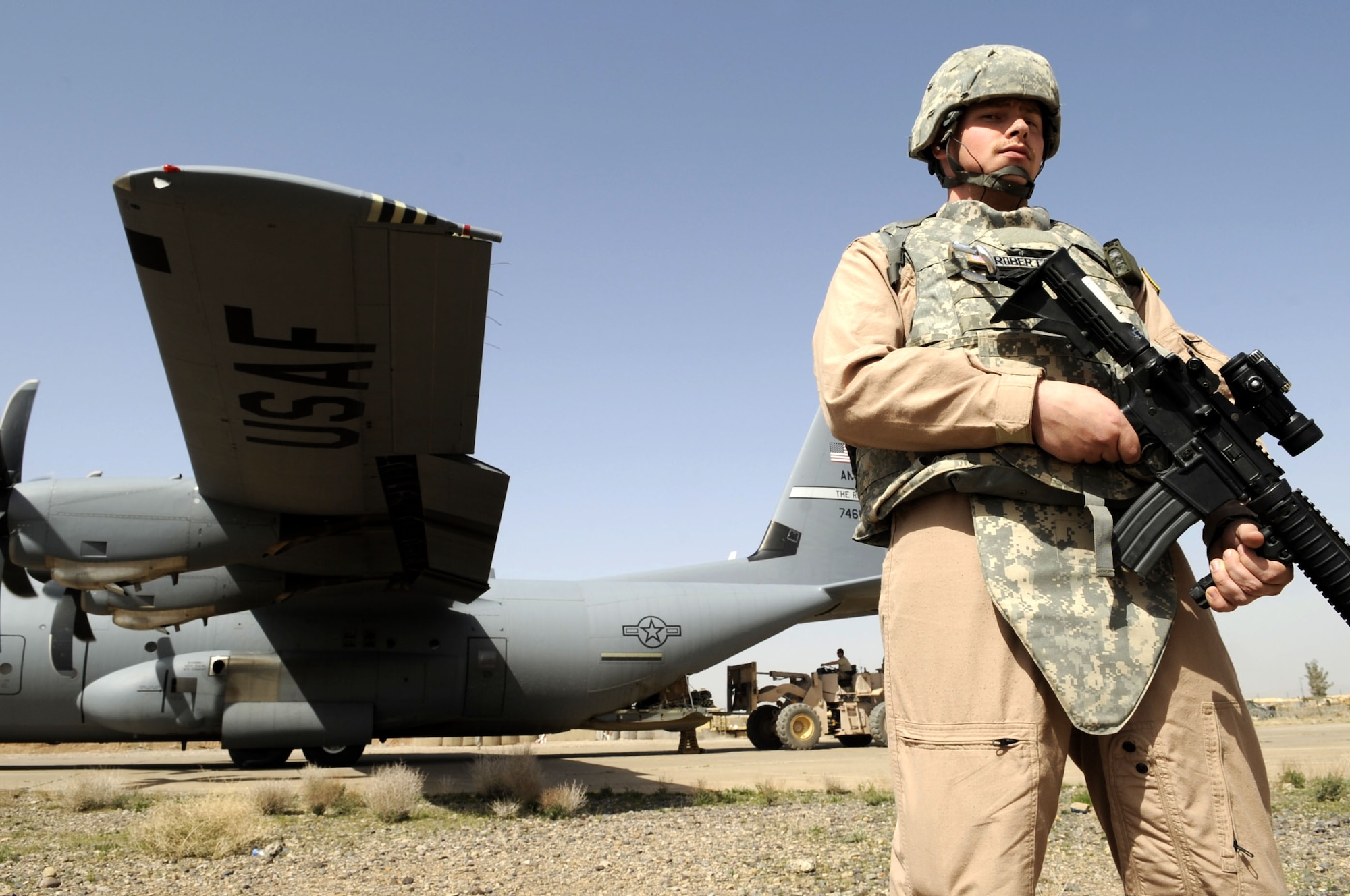 Senior Airman Edward Roberts, 451st Expeditionary Security Forces Squadron fly away security team member, provides ground security for a C-130J March 12 in Shindand, Afghanistan.  Airman Roberts is assigned to the 49th Security Forces Squadron at Holloman Air Force Base, NM.  (U.S. Air Force photo by Senior Airman Nancy Hooks/Released) 
