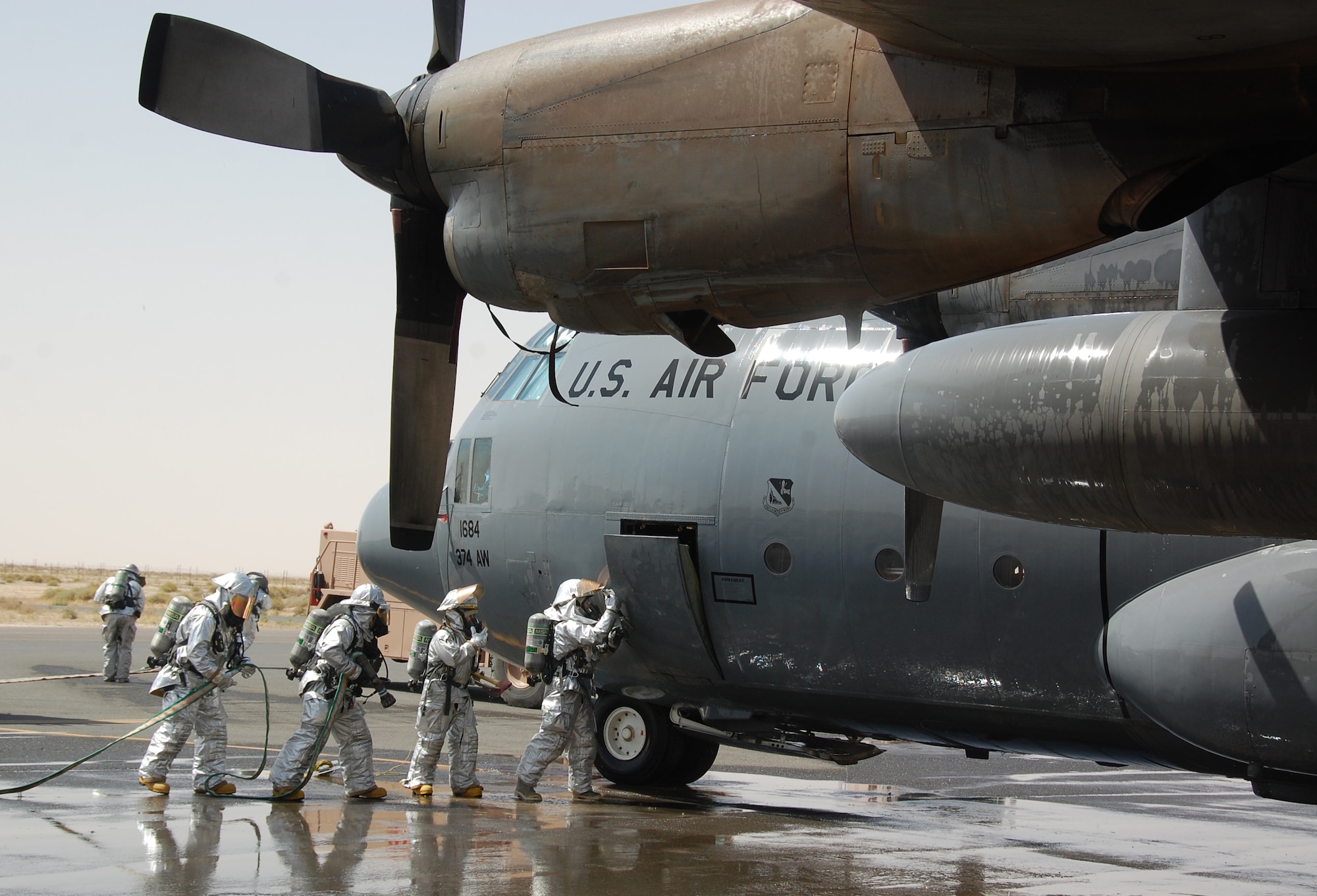 Firefighters with the 386th Expeditionary Civil Engineer Squadron conduct a C-130 egress training demonstration for local Boy Scouts and Cub Scouts March 13, 2010 as part of the scouts' tour of an air base in Southwest Asia. During the tour, the Scouts, who reside near the undisclosed location, visited with EOD, Fire Department and Military Working Dog Airmen; walked through C-130 and C-17 static displays on the flightline and ate lunch at the dining facility. (U.S. Air Force Staff Sgt. Lindsey Maurice/Released)