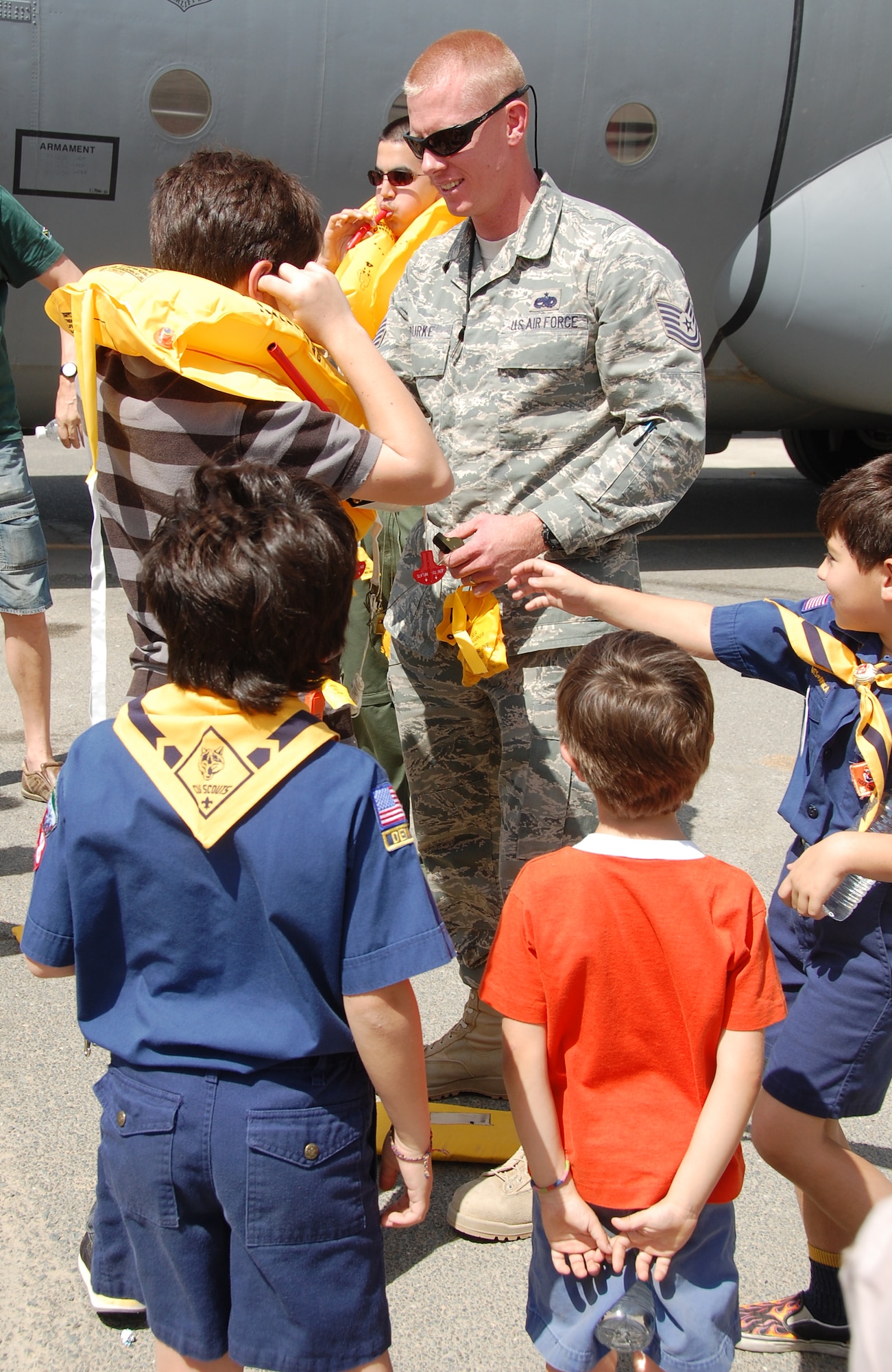 U.S. Air Force Tech. Sgt. Matthew Burke, 386th Expeditionary Maintenance Squadron, shows local Boy Scouts and Cub Scouts how to use a life preserver, during the scouts' tour of the 386th Air Expeditionary Wing March 13, 2010 at an air base in Southwest Asia. During the tour, the Scouts, who reside near the undisclosed location, visited with EOD, Fire Department and Military Working Dog Airmen; walked through C-130 and C-17 static displays on the flightline and ate lunch at the dining facility. (U.S. Air Force Staff Sgt. Lindsey Maurice/Released)