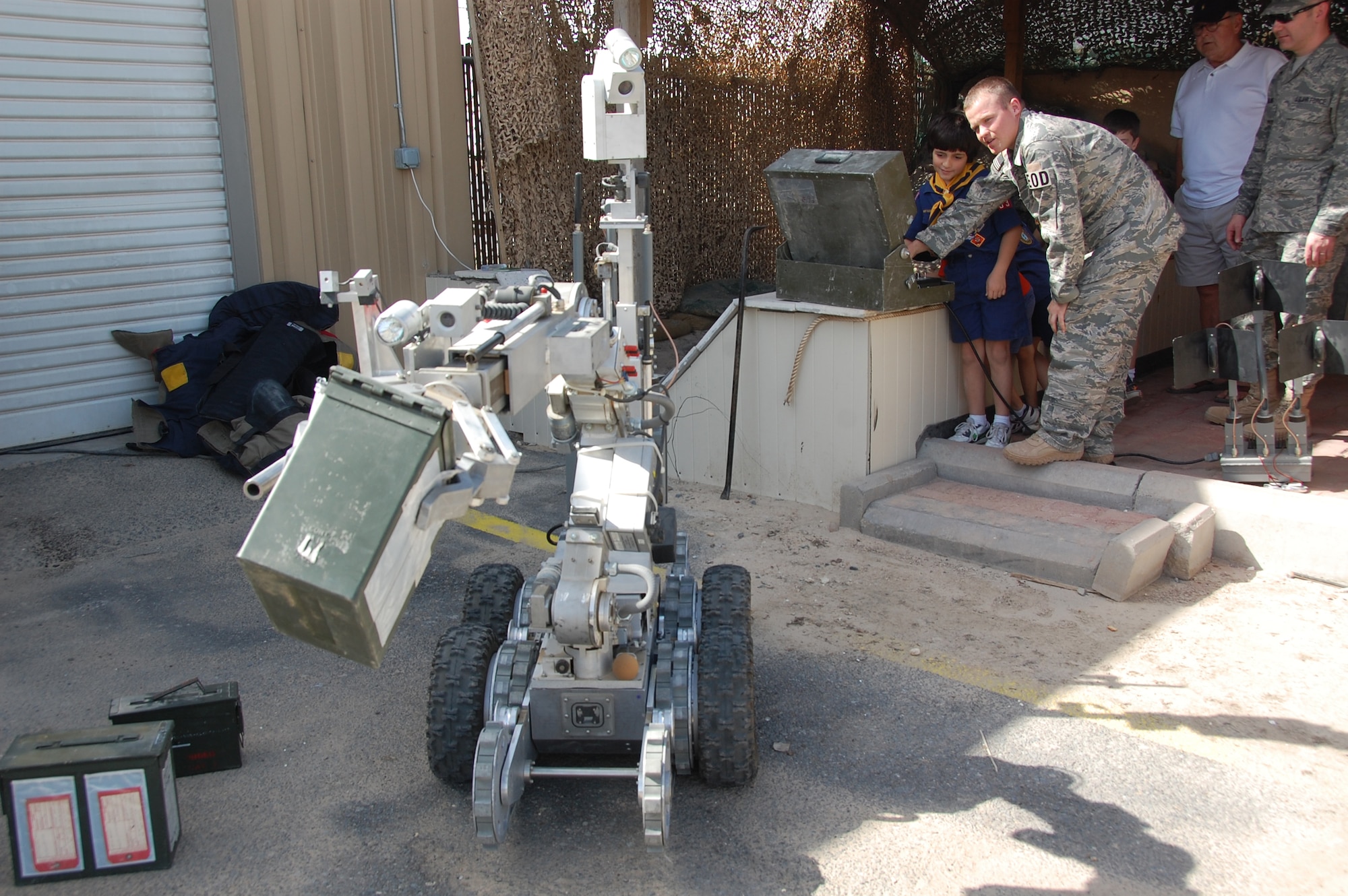 U.S. Air Force Airman 1st Class Devan Darnold, 386th Expeditionary Civil Engineer Squadron Explosive Ordnance Disposal, shows Cub Scout Zane Abal how to work the F6A, a remote procedures tool, during the scouts' tour of the 386th Air Expeditionary Wing March 13, 2010 at an air base in Southwest Asia. During the tour, the Boy Scouts and Cub Scouts, who reside near the undisclosed location, visited with EOD, Fire Department and Military Working Dog Airmen; walked through C-130 and C-17 static displays on the flightline and ate lunch at the dining facility. (U.S. Air Force Staff Sgt. Lindsey Maurice/Released)
