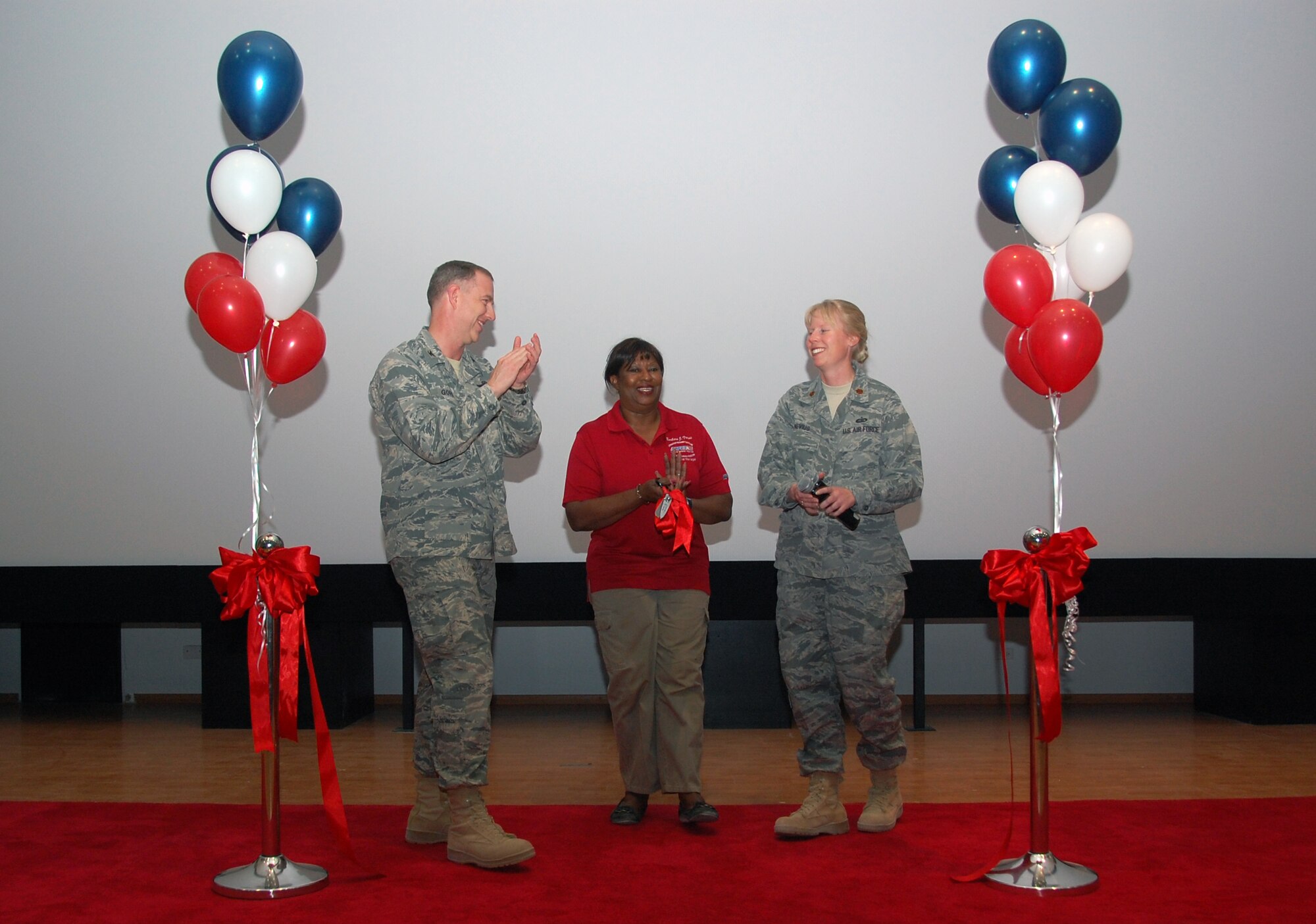 From left, U.S. Air Force Col. John R. Gordy II, 386th Air Expeditionary Wing commander; Barbara Travis, host nation AAFES general manager and Maj. Jennifer Nevius, 386th Force Support Squadron commander, cut a ribbon signifying the grand opening of the base theater here March 12, 2010 at an air base in Southwest Asia. (U.S. Air Force photo by Staff Sgt. Lindsey Maurice/Released)