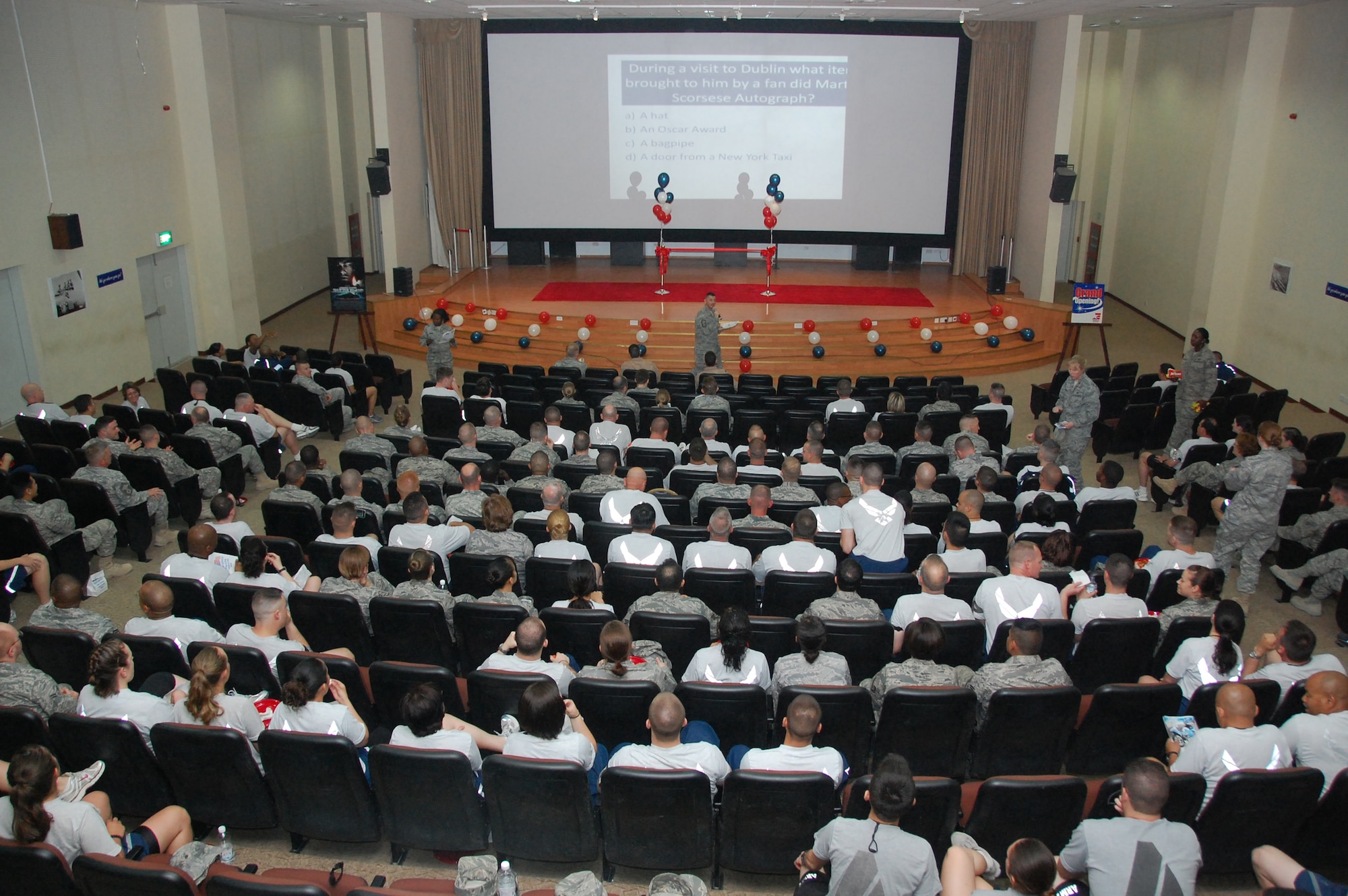 U.S. Air Force servicemembers enjoy free pizza and popcorn while answering movie trivia questions during the base theater grand opening celebration March 12, 2010 at an air base in Southwest Asia. (U.S. Air Force photo by Staff Sgt. Lindsey Maurice/Released)
