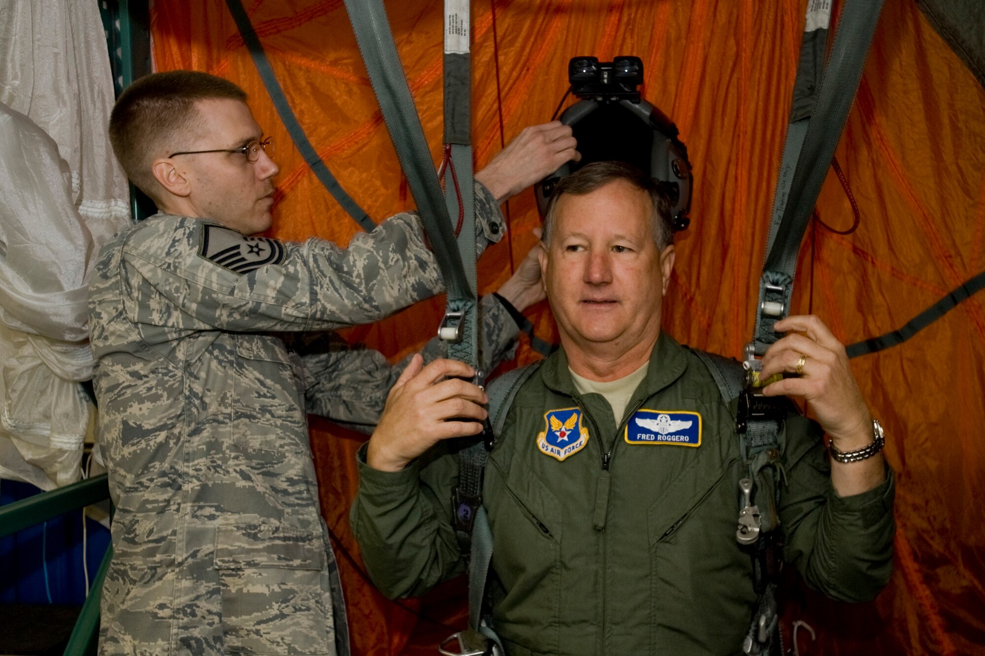 MISAWA AIR BASE, Japan -- Master Sgt. Jonathan Corp, 35th Operations Support Squadron aircrew flight equipment quality assurance representative, places a parachute-simulator helmet on Maj. Gen. Federick Roggero, Air Force Chief of Safety, March 10 at the 35th Operations Group headquarters. General Roggero visited the 35th OG as part of his tour of the base. (U.S. Air Force photo/Senior Airman Jamal D. Sutter)