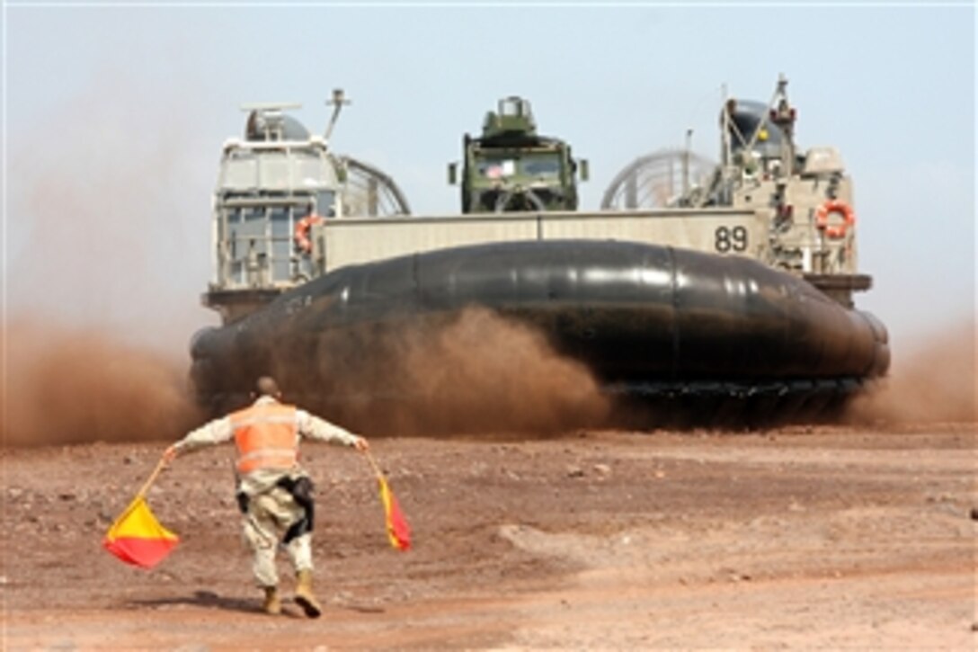 A U.S. service member directs a landing craft, air cushion carrying Marines and equipment onto the beach in Djibouti on March 4, 2010.  The Marines, who are assigned to Battalion Landing Team, 1st Battalion, 9th Marine Regiment and Combat Logistics Battalion 24, attached to the 24th Marine Expeditionary Unit, are in the area to conduct training and live-fire ranges.  