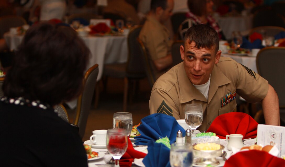 Sgt. Scott A. Whittington, Marine Corps Base Hawaii Kaneohe Bay's media chief, speaks with Li Garcia-Ballard, a guest at the event, during the 2nd Annual Individual Augmentee Recognition Luncheon March 17 at the Ala Moana Hotel in Honolulu. In May 2009, Whittington deployed to Afghanistan as an individual augment with 3rd Marine Regiment, 3rd Marine Division.