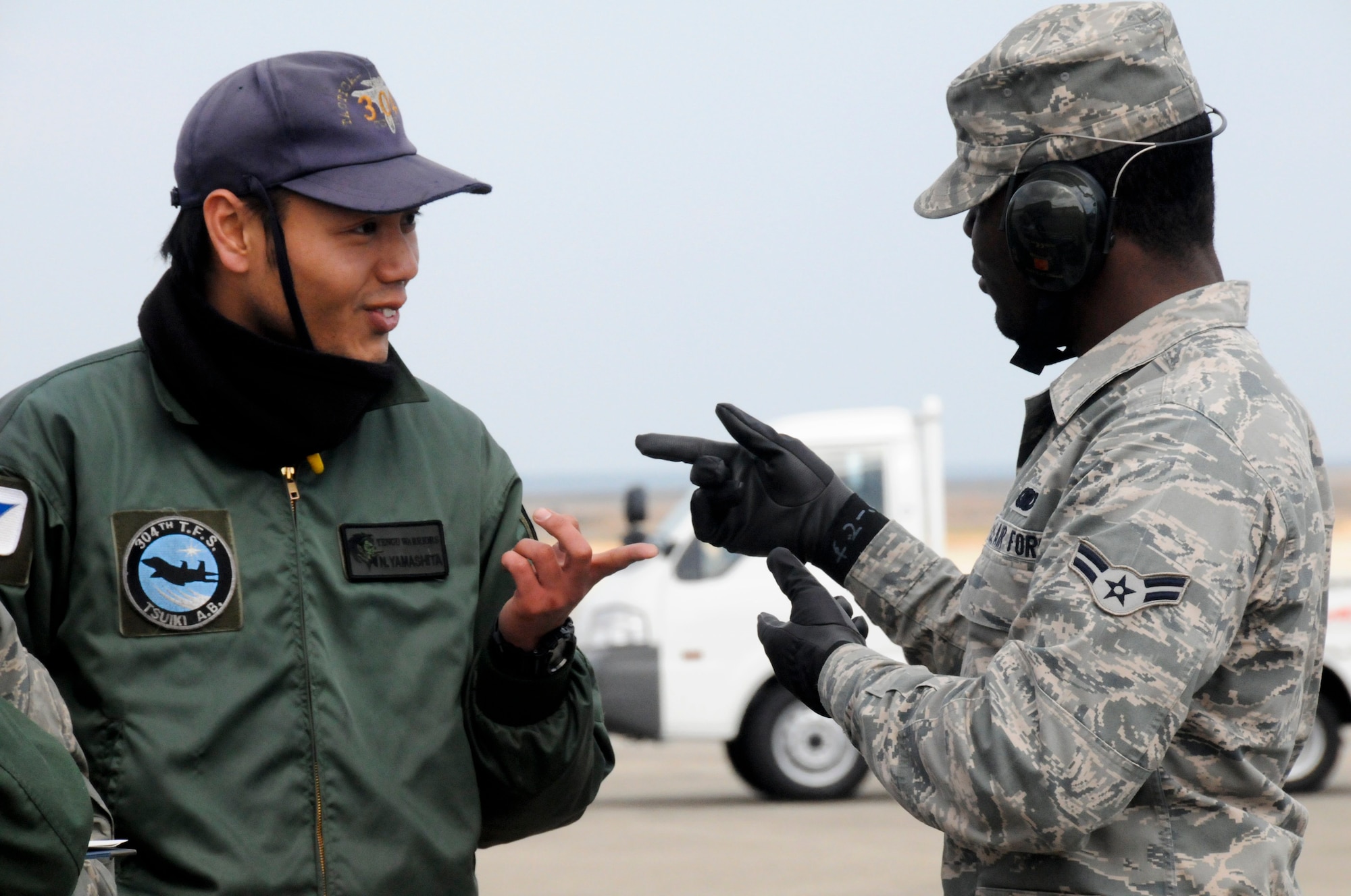 TSUIKI AIR BASE, Japan -- Airman 1st Class Curtis Watson, 35th Logistics Readiness Squadron fuels specialist, takes a break from refueling aircraft to talk with Japan Air Self-Defense Force crewchief Senior Airman Naoki Yamashita during an aviation training relocation exercise March 11. Airman Watson, who spent a week working in the JASDF fuels shop, said he enjoyed getting to know the JASDF Airmen both on and off duty. (U.S. Air Force photo/Staff Sgt. Rachel Martinez) 