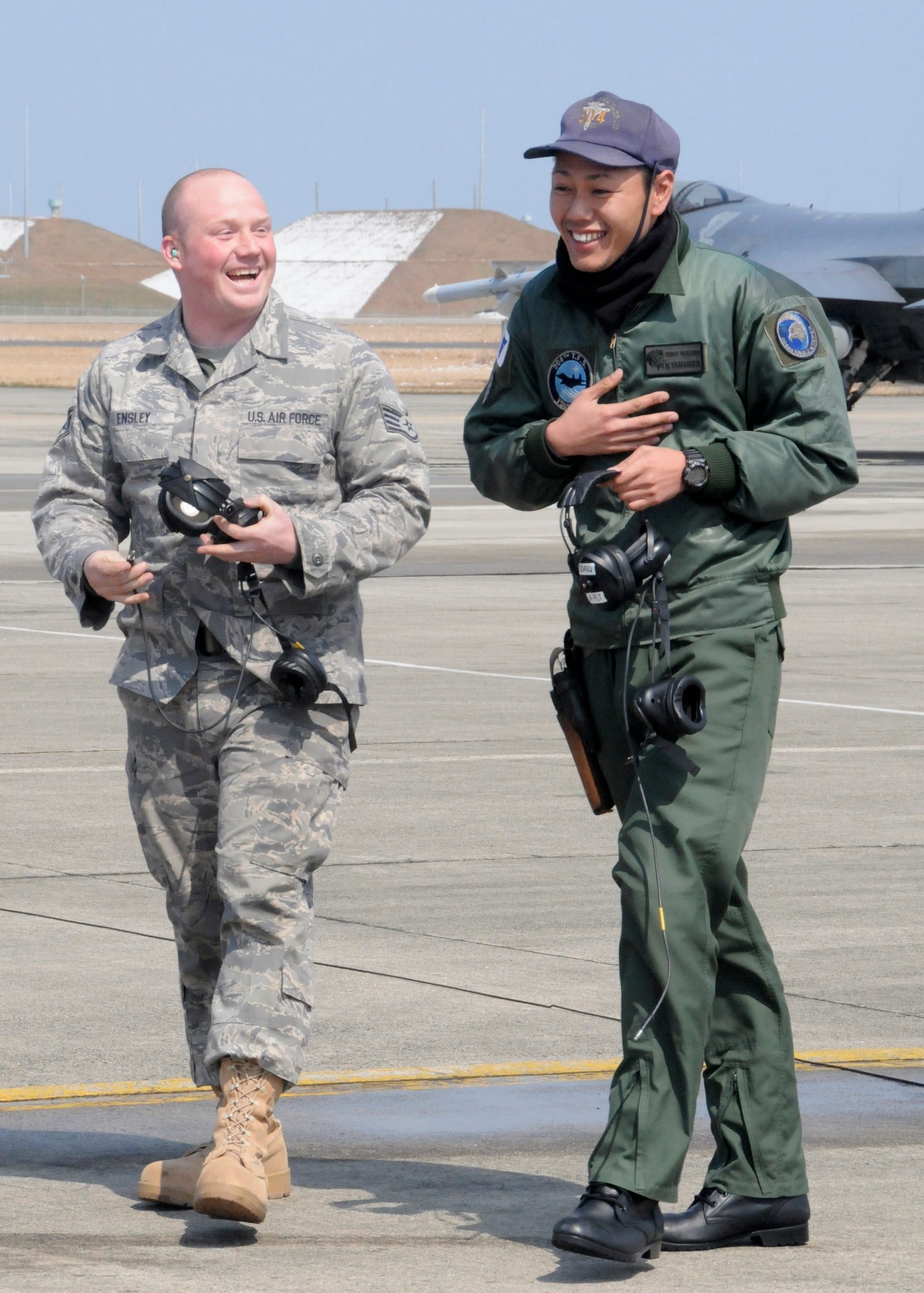 TSUIKI AIR BASE, Japan -- Staff Sgt. Robert Ensley, 35th Aircraft Maintenance Squadron crewchief, shares a laugh with Japan Air Self-Defense Force crewchief Senior Airman Naoki Yamashita after launching an F-16 Fighting Falcon together March 11. Sergeant Ensley, who participated in a cross-familiarization program with the JASDF, said it was the most fun he has had on the flightline in a long time. (U.S. Air Force photo/Staff Sgt. Rachel Martinez)