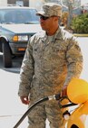 Despite being located underneath an overhang, Senior Airman Nathaniel John, 9 OSS, fills up his tank with his cover on at the Beale Air Force Base, Calif. AFFES gas station on Doolittle road.