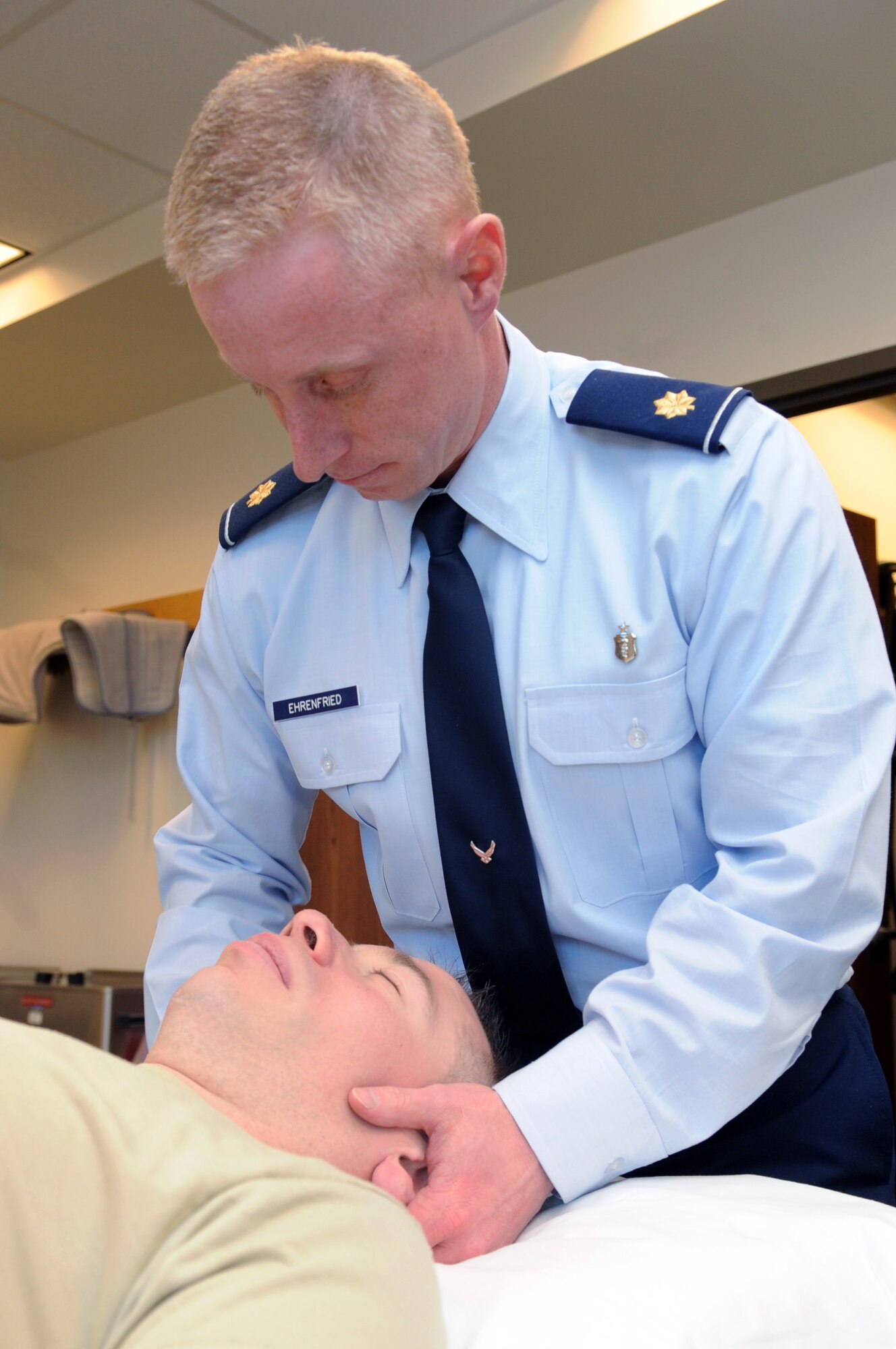BUCKLEY AIR FORCE BASE, Colo. -- Maj. John Ehrenfried, 460th Medical Group head of physical therapy, performs a cervical and thoraic manipulation on 1st Lt. Kevin Hooker, 460th Medical Group Mental Health Clinic officer in charge March 16.  ( U.S. Photo by Airman 1st Class Marcy Glass )