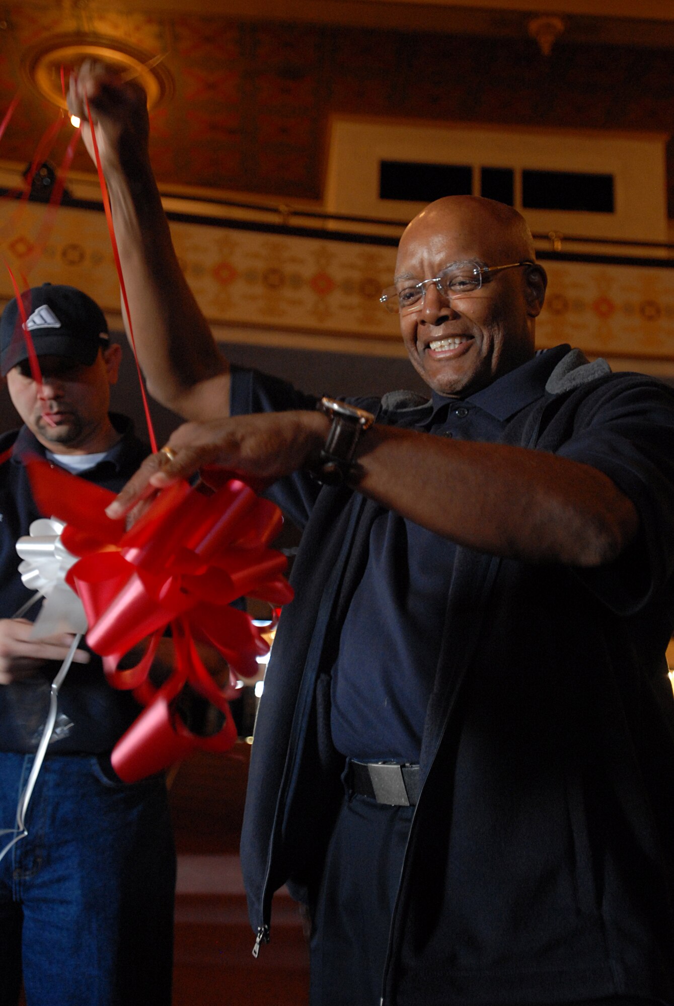 GOODFELLOW AIR FORCE BASE, Texas – Cravin Ham, 17th Force Support Squadron Event Center director and Rick Rey, 17 FSS Recreation director, foreground, set up bows and decorations at the San Angelo City Auditorium March 12. Mr. Ham and Rey are project officers for the Tops in Blue tour to San Angelo. They have been working with the Tops in Blue team for more than six months to ensure logistical and administrative paper work were complete, that the auditorium and lodging has been reserved as well transportation for the 33 member entertainment group. (U.S. Air Force photo/ Senior Airman Tong Duong)
