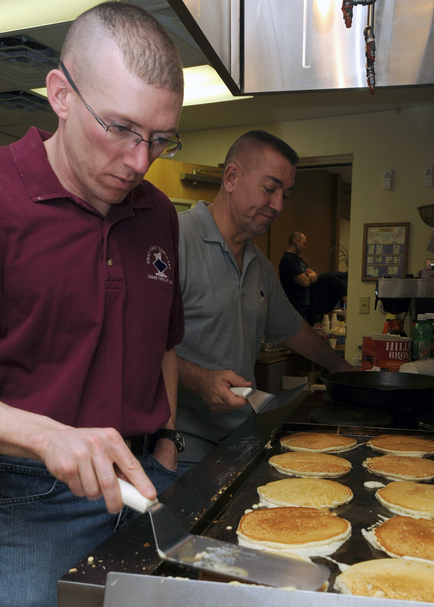 Senior Master Sgt. Ronald Beadles (left), 319th Aircraft Maintenance Squadron first sergeant, and Master Sgt. Darwin Garman, 319th Medical Group first sergeant, cook pancakes March 16 at Sven’s Den on Grand Forks Air Force Base, N.D.  The base’s first sergeants held a breakfast to raise money for Airmen. (U.S. Air Force photo by Airman 1st Class Amber Price)