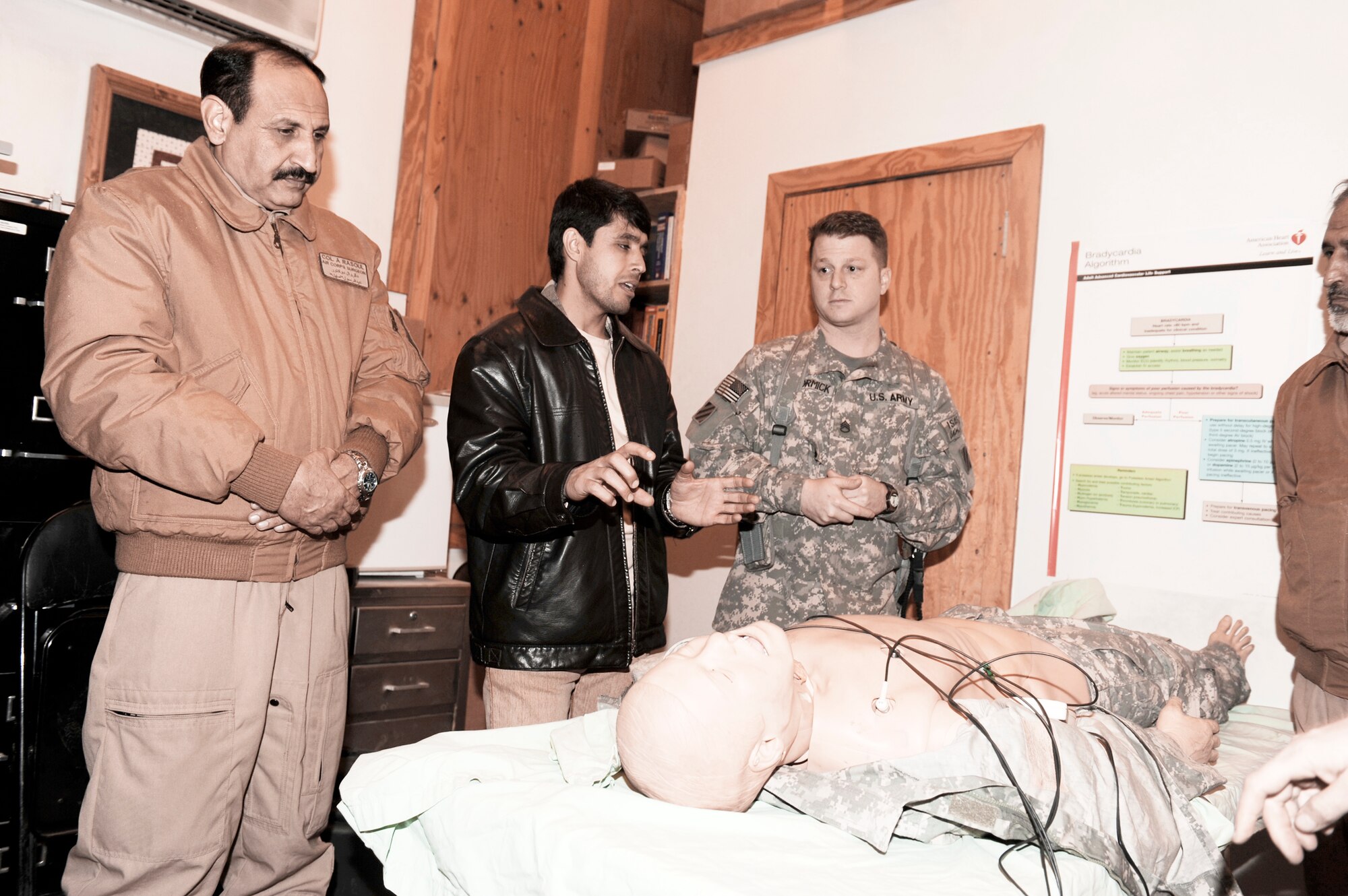 Army Staff Sgt. Joseph McCormick shows Col. Abdul Rasoul (left), Afghan National Army Air Corps surgeon general, and other members of the ANAAC how U.S. forces train for medical emergencies.  The ANAAC members were at Bagram Airfield March 6, 2010, to discuss the evolution of the medical evacuation mission in Afghanistan. (U.S. Air Force photo/Tech. Sgt. Jeromy K. Cross)