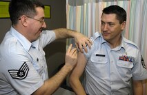 MINOT AIR FORCE BASE, N.D. -- Staff Sgt. Christopher Brown, 5th Medical Operations Squadron allergy and immunizations technician, administers an intramuscular shot to Master Sgt. Gene Presciti, 5th MDOS primary care flight chief, at the Allergy and Immunizations Clinic in the 5th Medical Group March 11. A typical intramuscular shot may include anthrax, typhoid or tetnis. (U.S. Air Force photo by Senior Airman Benjamin Stratton)