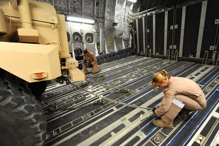 Senior Airmen Christine Collier, left, and Spencer Keeley, right, both 816th Expeditionary Airlift Squadron loadmasters, secure a mine-resistant, ambush-protected vehicle in a C-17 Globemaster III at a non-disclosed Southwest Asia location March 10, 2010. Airmen Collier and Keeley were part of an all-female crew in honor of Women's History Month and are deployed from the 14th Airlift Squadron. (U.S. Air Force photo by Senior Airman Kasey Zickmund)