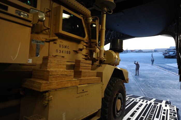 Senior Airman Spencer Keeley, 816th Expeditionary Airlift Squadron loadmaster, directs a mine-resistant, ambush-protected vehicle as it is unloaded from a C-17 Globemaster III from non-disclosed Southwest Asia location March 10, 2010. Airman Keeley was part of an all-female crew in honor of Women's History Month and is deployed from the 14th Airlift Squadron. (U.S. Air Force photo by Senior Airman Kasey Zickmund)