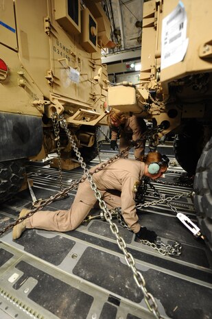 Master Sgt. Lisa Peele, front, 816th Expeditionary Airlift Squadron first sergeant, and Senior Airman Spencer Keeley, back, 816 EAS loadmaster, unsecure mine-resistant, ambush-protected vehicles in a C-17 Globemaster III in preparation for delivery from a non-disclosed Southwest Asia location March 10, 2010. Sergeant Peele and Airman Keeley were part of an all-female crew in honor of Women's History Month and are deployed from the 14th Airlift Squadron. (U.S. Air Force photo by Senior Airman Kasey Zickmund)
