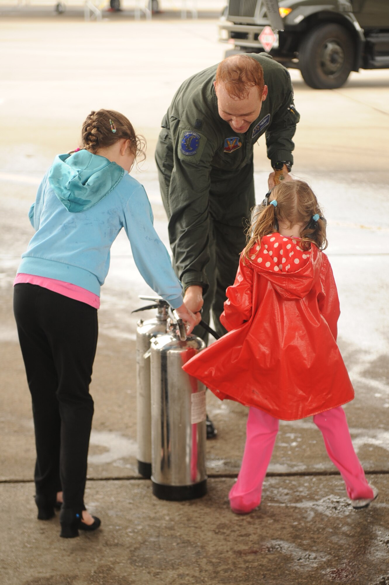 Lt. Col. Jason Brenneman, 4th Operations Support Squadron operations flight commander, is hosed by his daughters, Alyssa, 8, and Marlena, 4, after his final flight in the F-15E Strike Eagle on Seymour Johnson Air Force Base, N.C., March 12, 2010. Brenneman has served in the Air Force for more than 17 years and will continue his career at the Air Force Academy as the airfield director of operations. Brenneman is from Lexington, Mo. (U.S. Air Force photo/Senior Airman Ciara Wymbs) 
