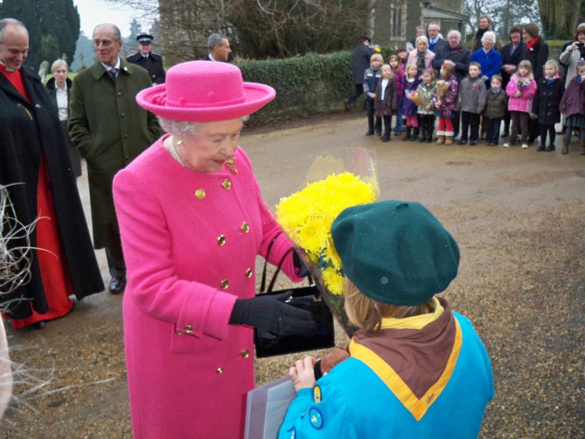 Freedom Scott, age 7, presents the Queen a poppy flower he made and a picture of their previous visit during Christmas Feb. 7. Freedom Scott is the son of Major Dennis and Peg Tansley. Major Tansley is assigned to the 423rd Medical Squadron. (Courtesy of Tansley Family)