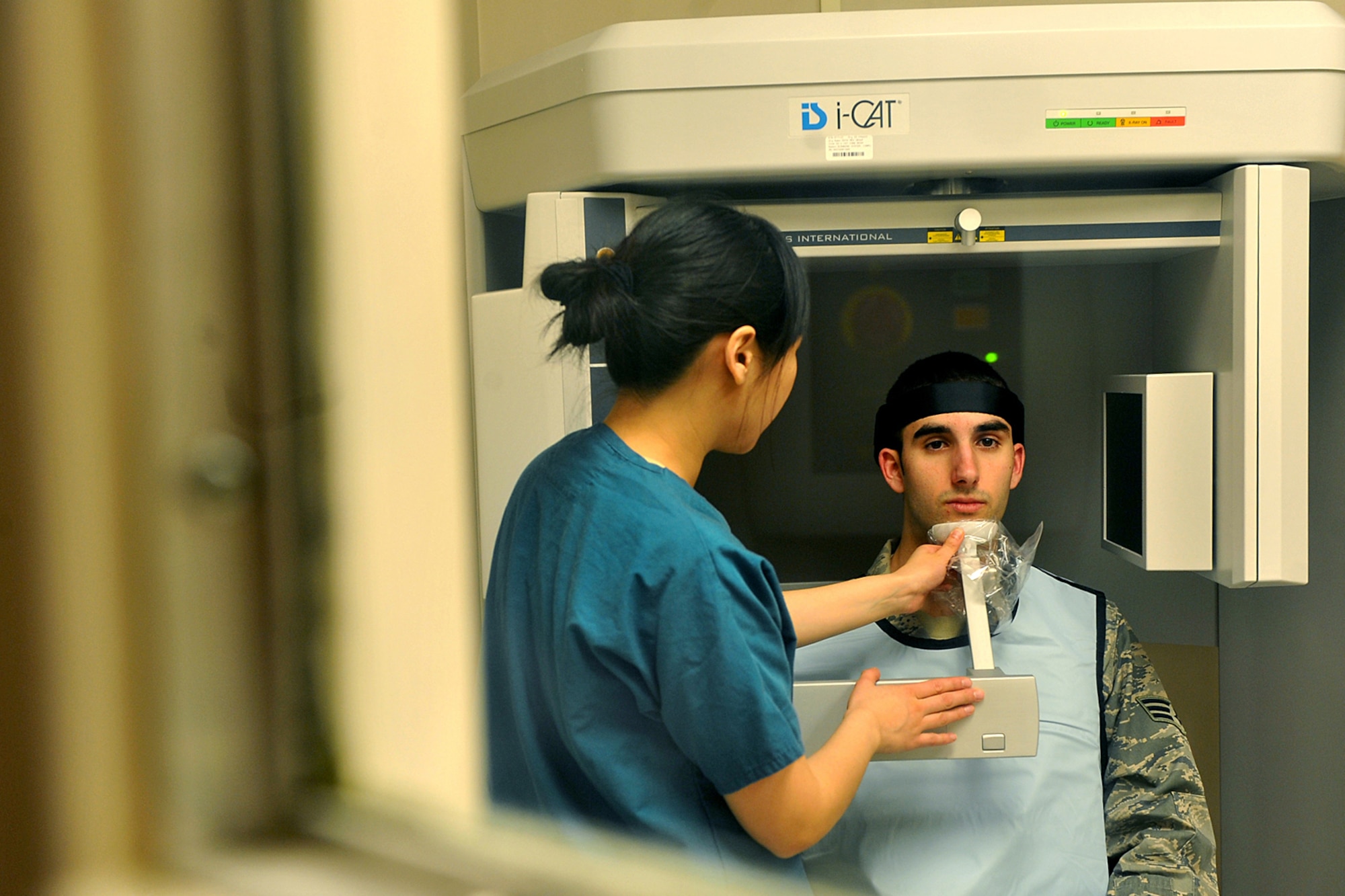OFFUTT AIR FORCE BASE, Neb. - Staff Sgt. Jessica Chang, adjusts the chin piece on an I-cat imaging machine for Senior Airman Kalen Sanchez, also with the 55th Dental Squadron, inside the dental facility at the Ehrling Bergquist Clinic March 11. The 55th DS's orthodontics section provides support to an average of 150-200 patients each month for dental services and treatment.   

U.S. Air Force photo by Charles Haymond