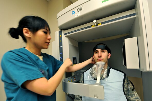 OFFUTT AIR FORCE BASE, Neb. -  Staff Sgt. Jessica Chang, with the 55th Dental Squadron,adjusts the chin piece on an I-cat imaging machine for fellow squadron member Senior Airman Kalen Sanchez inside the dental facility at the Ehrling Bergquist Clinic March 11. The 55th DS's orthodontics section provides support to an average of 150-200 patients each month for dental services and treatment.

U.S. Air Force photo by Charles Haymond
