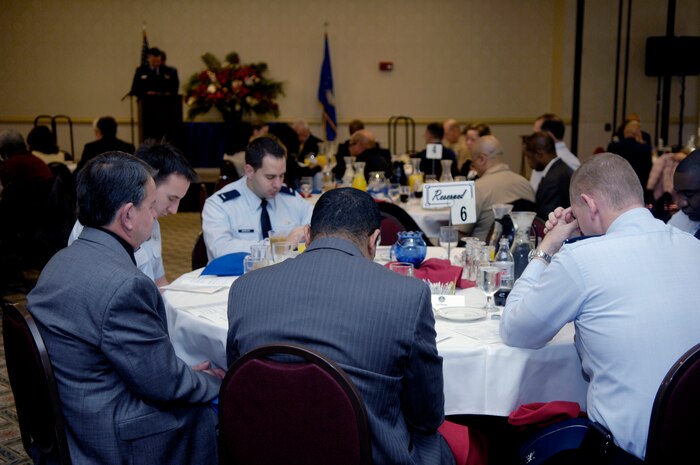 Members of Team Charleston bow their heads in prayer as Maj. John Painter leads the "Prayer for the Nation" during the National Prayer Breakfast held at the Charleston Club March 15. Originally called the Presidential Prayer Breakfast, the name was changed to the National Prayer Breakfast in 1970. During the breakfast, numerous speakers read selections from Hebrew scripture and the Bible. Major Painter is a chaplain with the 315th Airlift Wing. (U.S. Air Force photo/Airman 1st Lauren Main)