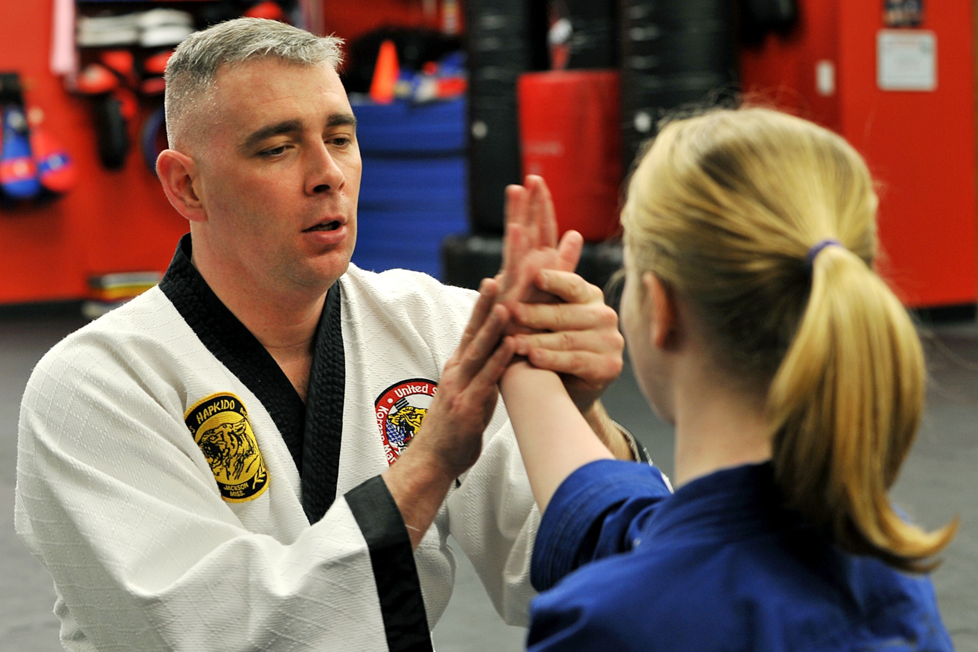 OFFUTT AIR FORCE BASE, Neb. - Technical Sgt. Michael Munyon, with the 55th Security Forces Squadron, teaches Abby Wolfe how to take down an opponent from the seated position during a hapkido class at an Omaha dojang March 12. Sergeant Munyon currently holds a 5th degree black belt in Taekwondo and a 2nd degree black belt in Hapkido, another form of Korean martial arts. He was recently inducted into the Masters Hall of Fame.

U.S. Air Force photo by Charles Haymond