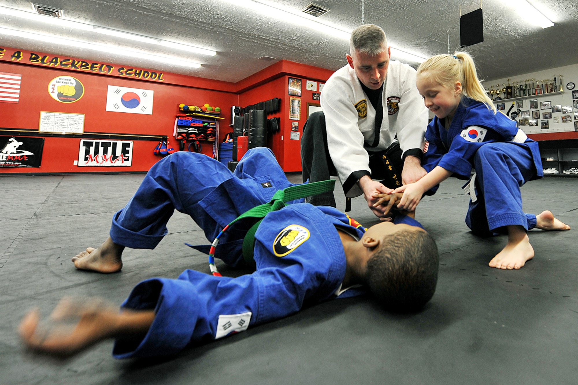 OFFUTT AIR FORCE BASE, Neb. - Gordon Taylor taps out when Tech. Sgt. Michael Munyon, with the 55th Security Forces Squadron, and Sophie Wolfe apply pressure to his wrist during a hapkido class at an Omaha dojang March 12. Sergeant Munyon currently holds a 5th degree black belt in Taekwondo and a 2nd degree black belt in Hapkido, another form of Korean martial arts. He was recently inducted into the Masters Hall of Fame.

U.S. Air Force Photo by Charles Haymond