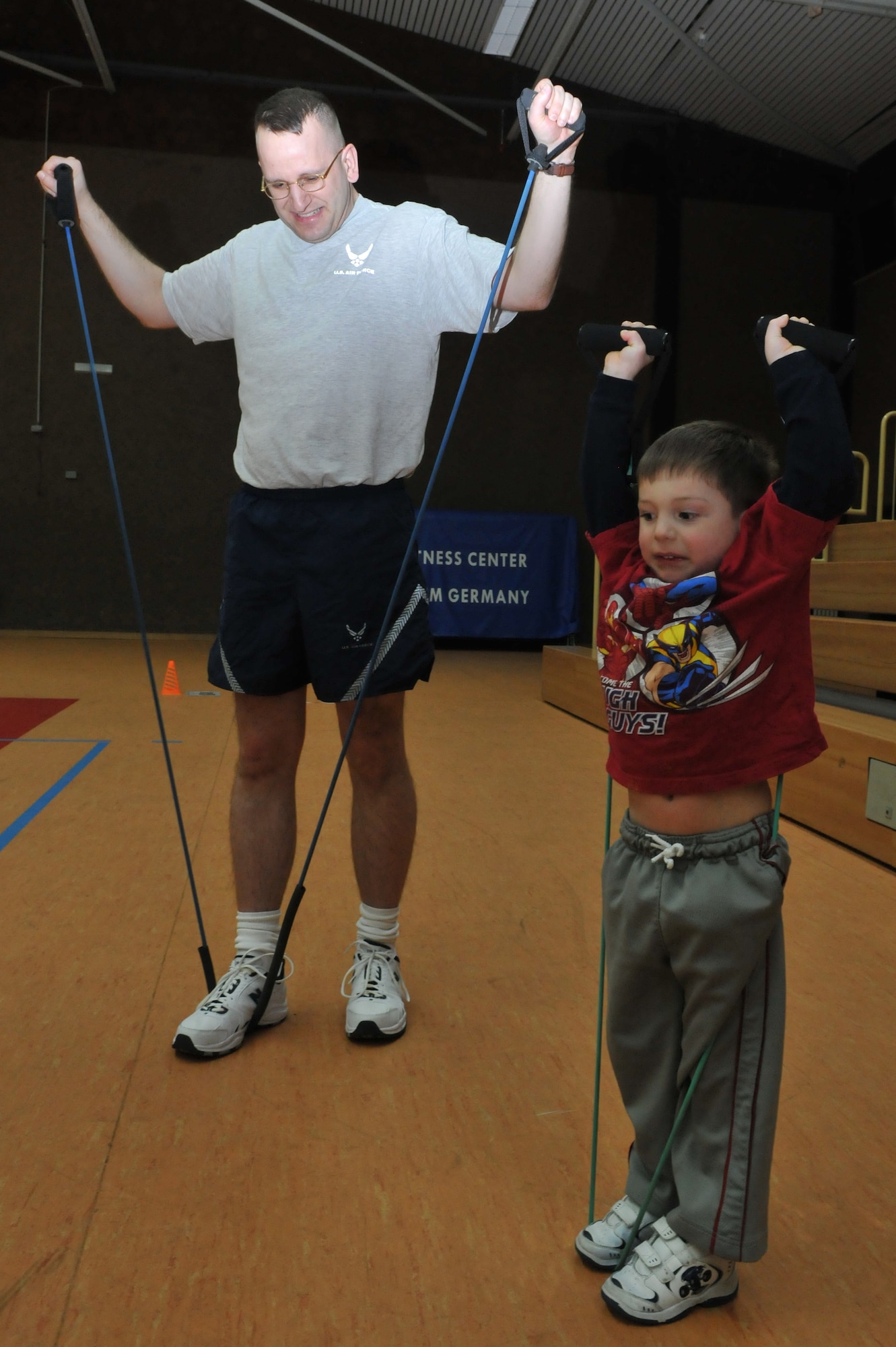 SPANGDAHLEM AIR BASE, Germany – Capt. Chris Anderson, 52nd Force Support Squadron sustainment services flight commander, performs lateral raises with his 4-year-old son, Luke, during a family circuit training class March 12 in the Skelton Memorial Fitness Center. Classes are held 6-7p.m. every Friday. Children 6 years old and older are allowed to participate. (U.S. Air Force photo/Airman 1st Class Nick Wilson)