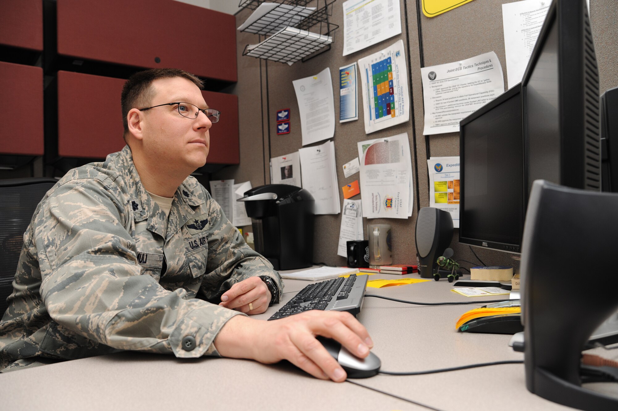 Lt. Col. Ralph Muli, U.S. Air Force Expeditionary Center chief of Tactics, Techniques and Procedures Division, works at his computer March 17, sorting through details of standing up the 422 Joint Tactics Squadron that will be assigned to the Expeditionary Center.  The squadron will fall under the Expeditionary Center's Expeditionary Operations School with its sister squadron, the 421 Combat Training Squadron.  The ceremony is scheduled for March 26. (U.S. Air Force Photo/Staff Sgt. Nathan G. Bevier)