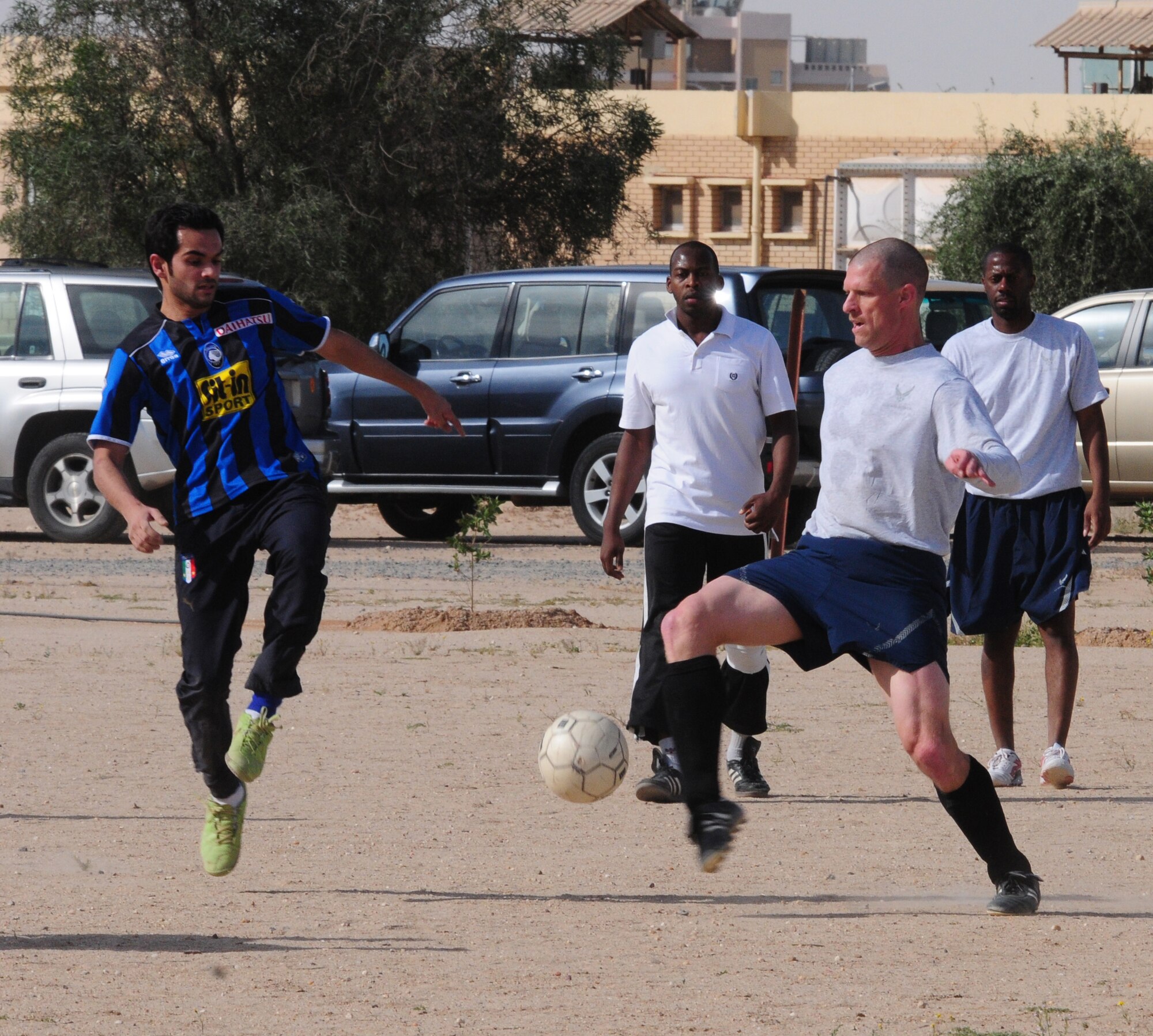 U.S. Air Force Senior Airman Trevor Smith, hustles past a host nation defender during a soccer match March 16, 2010 at an air base in Southwest Asia. The 386th Air Expeditionary Wing team defeated the host nation base team 3-0 to claim the championship trophy. (U.S. Air Force photo by Staff Sgt. Lakisha A. Croley/Released)