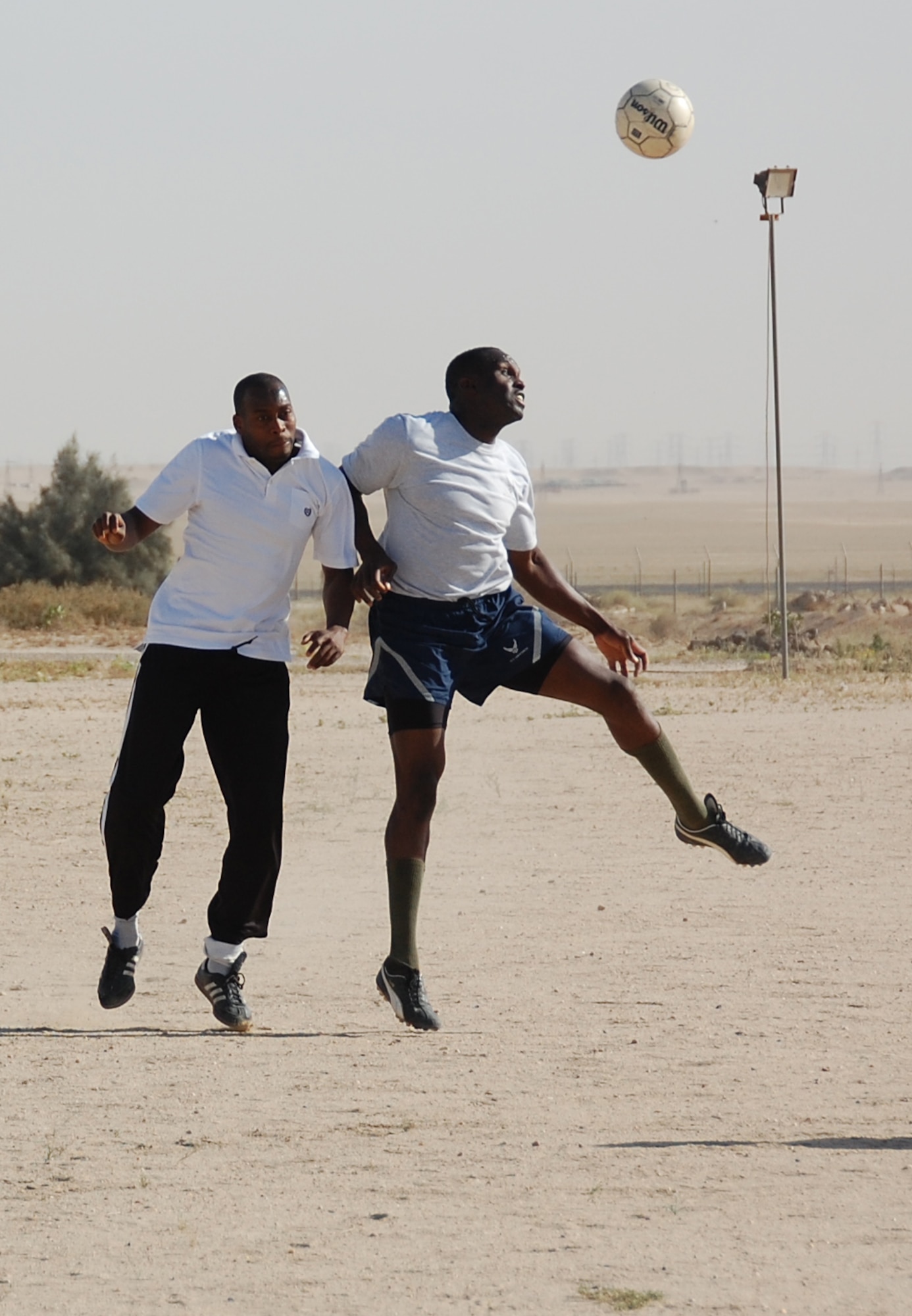 U.S. Air Force Staff Sgt. Chaderton Adams fights for the ball against the host nation defense during a soccer match March 16, 2010 at an air base in Southwest Asia. The 386th Air Expeditionary Wing team defeated the host nation base team 3-0 to claim the championship trophy. (U.S. Air Force photo by Staff Sgt. Lindsey Maurice/Released)