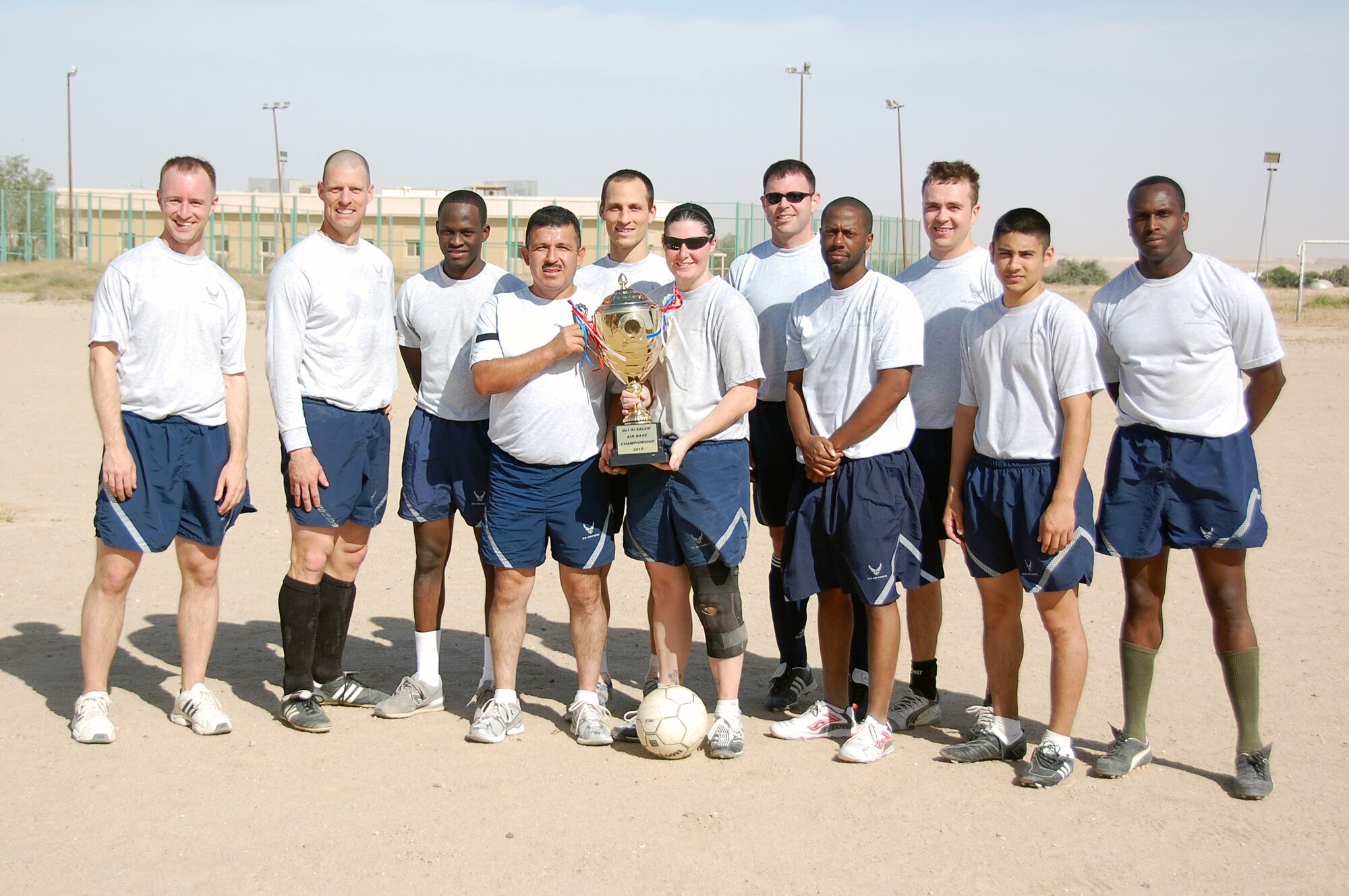 U.S. Air Force members of the 386th Air Expeditionary Wing soccer team, from left, Capt. Matthew Olson, Senior Airman Trevor Smith, Senior Airman Serge Exume, Staff Sgt. Javier Vidal, 2nd Lt. Jason Blair, Senior Airman Laura Henkenmeier, Maj. David Decoursey, Staff Sgt. Jauron Myles, Staff Sgt. Nathan Wik, Senior Airman Peter Dominguez and Staff Sgt. Chaderton Adams celebrate their first victory over the host nation base soccer team March 16, 2010 at an air base in Southwest Asia. The 386th AEW defeated the host nation team 3-0. (U.S. Air Force photo by Staff Sgt. Lindsey Maurice/Released)