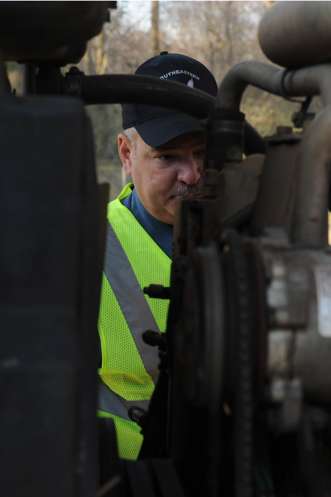 Louis Bechel, Southeastern Protective Services security officer, checks a truck's engine for suspicious objects on Seymour Johnson Air Force Base, N.C., March 9, 2010. Bechel searches for anything abnormal or suspects such as drugs, alcohol, illegal weapons and explosives. Bechel is from Pikeville, N.C. (U.S. Air Force photo/Senior Airman Whitney Lambert)