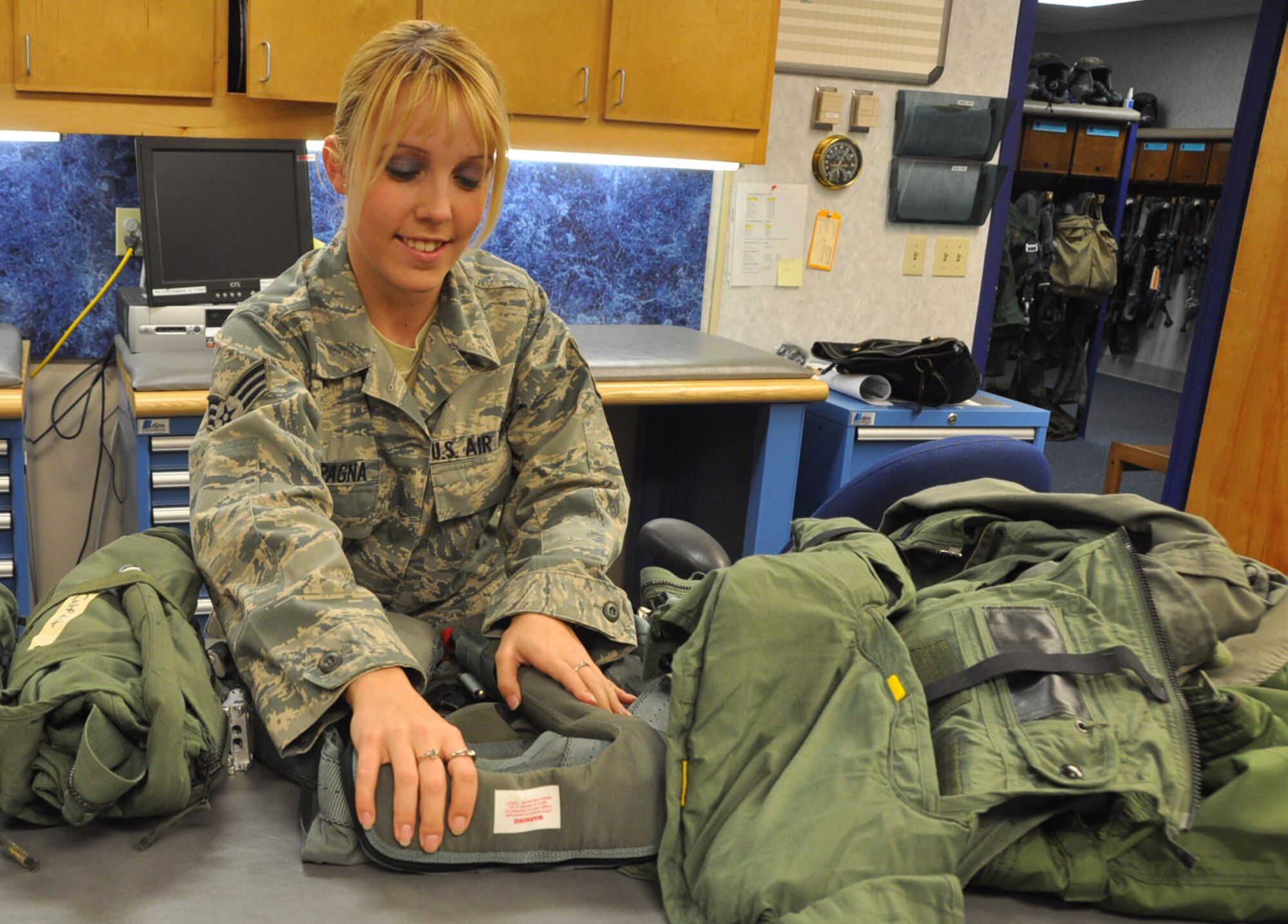 Senior Airman Kristen Campagna, 325th Operations Support Squadron Aircrew Flight Equipment journeyman, inspects a harness in preparation for flying March 12 at the 95th Fighter Squadron. (U.S. Air Force photo by Airman 1st Class Rachelle Elsea)
