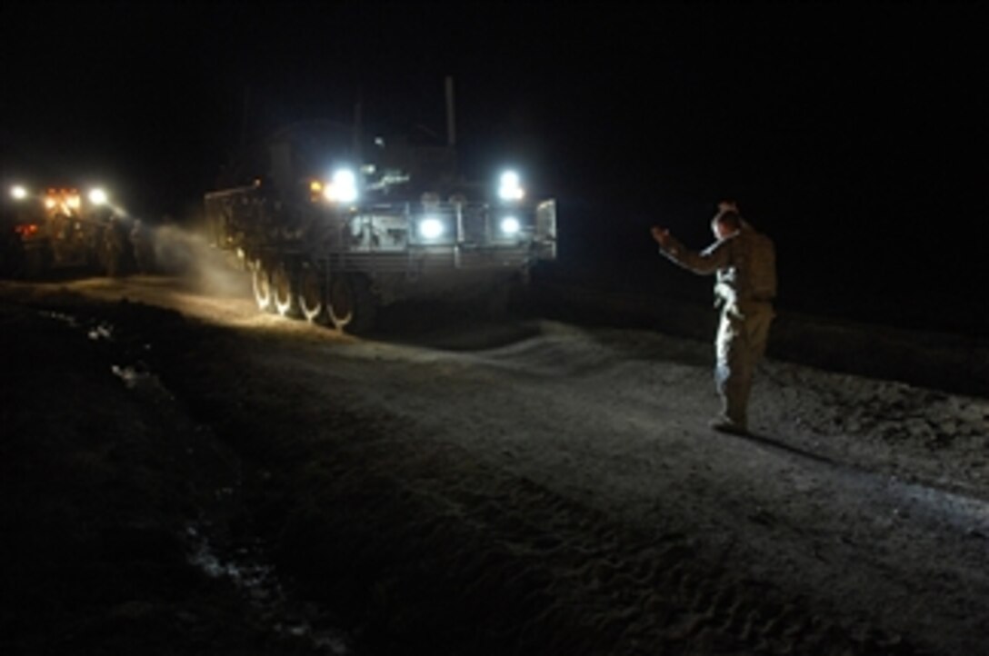 U.S. Army Spc. Jeffery L. Petta, with Bear Troop, 8th Squadron, 1st Cavalry Regiment, directs a driver to a safe spot on the road after a wrecker pulled a Stryker armored vehicle out of a ditch in Robat, Afghanistan, on March 12, 2010.  