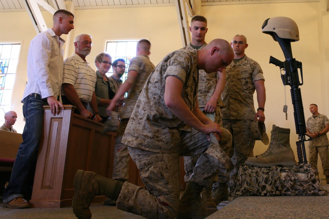 Marines pay their respects and consol the family at the Marine Memorial Chapel here to mourn the death of a fellow comrade, March 15. Sgt. Thomas A. Elliott, 24, from Horseheads, N.Y., explosive ordnance disposal technician, Combat Logistics Battalion 13, Combat Logistics Regiment 17, 1st Marine Logistics Group, died from injuries sustained while off duty, March 9.