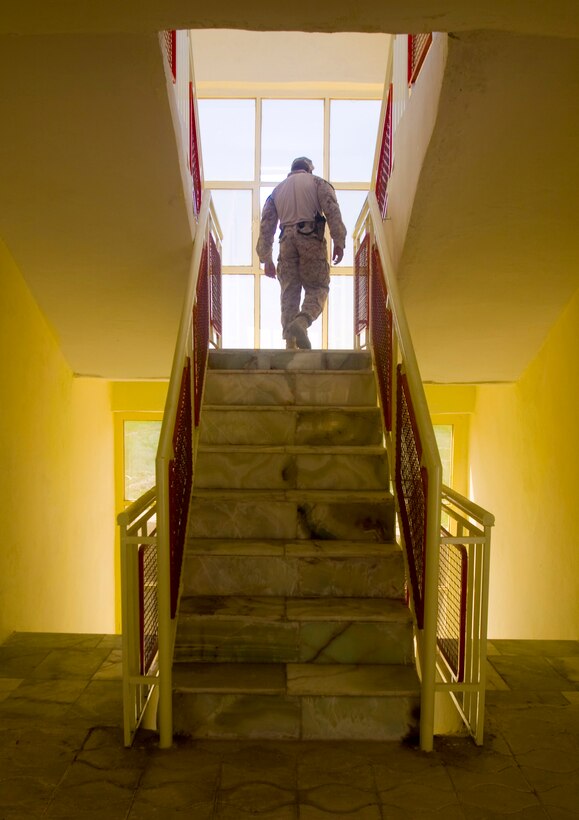 Sgt. Maj. Dwight D. Jones, sergeant major of 1st Battalion, 3rd Marine Regiment, climbs the central staircase of Nawa’s District Governance Center during a tour March 17.  The building was officially opened in a ceremony April 18 by Helmand Provincial Governor Gulab Mangal and local government leaders from Nawa.
