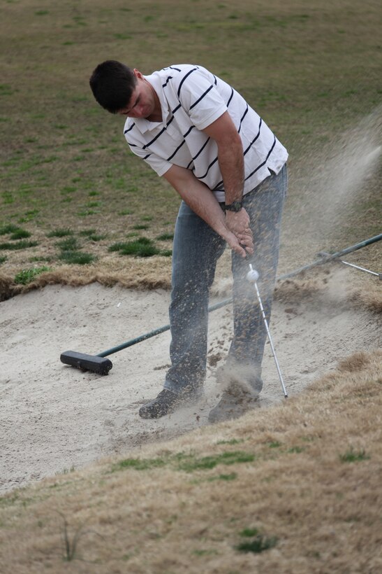 Sgt. Paul Davis, an explosive ordnance disposal technician with Marine Wing Support Squadron 271, digs his way out of a sand trap during the 3rd annual 18 Hole Par 3 Tournament held at Cherry Point’s Sound of Freedom Golf Course, March 17. More than 60 golfers participated in the tournament.