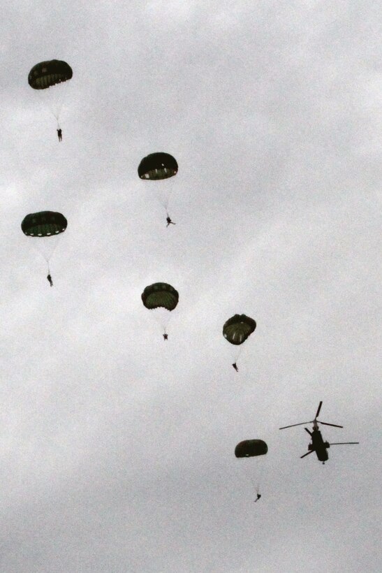U.S. Army paratroopers with 1st Battalion, 1st Special Forces Group Airborne, are dropped out of a Marine CH-46E Sea Knight helicopter over Ie Shima, Japan, Nov. 29. The helicopter crew supported static-line parachute operations, giving the paratroopers an opportunity to practice and train with Marine pilots. The pilots are with Marine Medium Helicopter Squadron 262, Marine Aircraft Group 36, 1st Marine Aircraft Wing.
