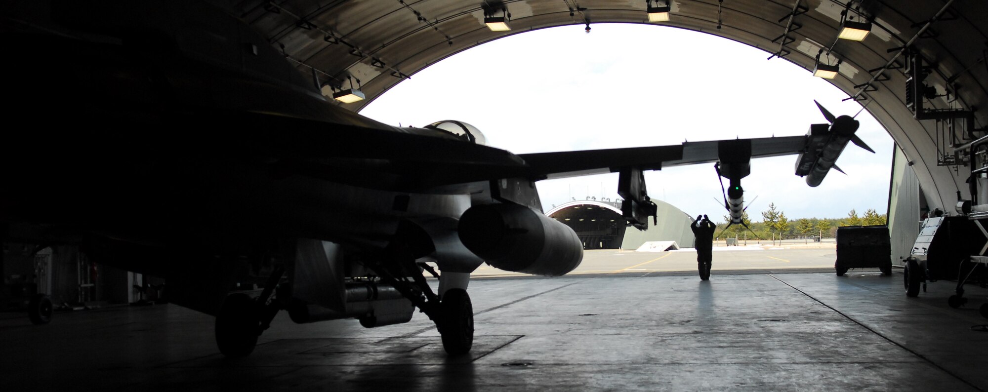 MISAWA AIR BASE, Japan – Staff Sgt. Donald Slayton, 13th Aircraft Maintenance Unit dedicated crew chief, marshals Maj. Dylan Baumgartner, 35th Fighter Wing chief of wing inspections, out of a hardened aircraft shelter for his mission March 16. The F-16 Fighting Falcon is a compact, multi-role fighter aircraft. It is highly maneuverable and has proven itself in air-to-air combat and air-to-surface attack. (U.S. Air Force photo/Staff Sgt. Phillip Butterfield)