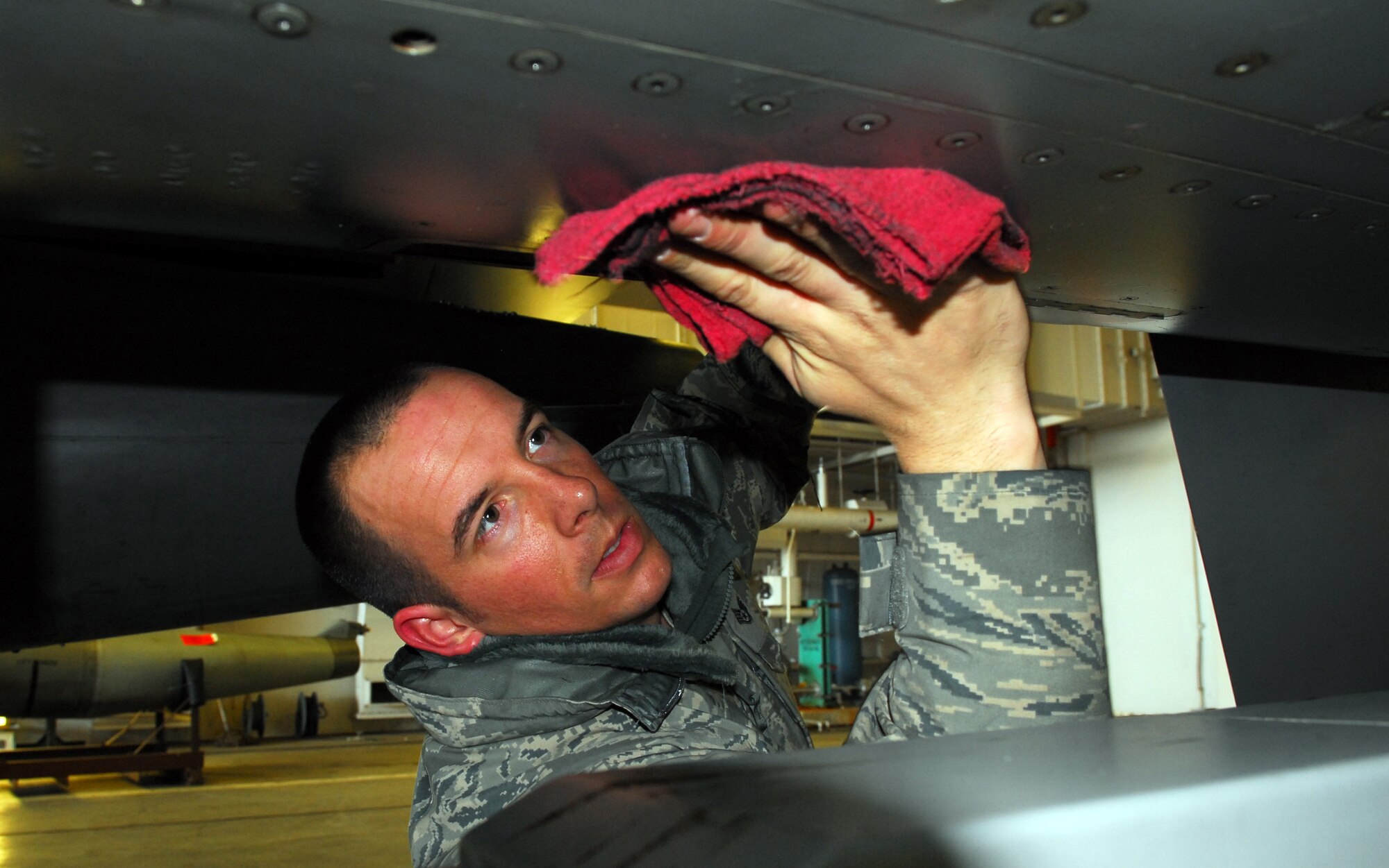 MISAWA AIR BASE, Japan – Staff Sgt. Donald Slayton, 13th Aircraft Maintenance Unit dedicated-crewchief, wipes down his aircraft prior to launch March 16 in a hardened aircraft shelter. As a DCC, Sergeant Slayton is assigned to a single aircraft and is responsible for all maintenance on that aircraft. (U.S. Air Force photo/Staff Sgt. Phillip Butterfield)
