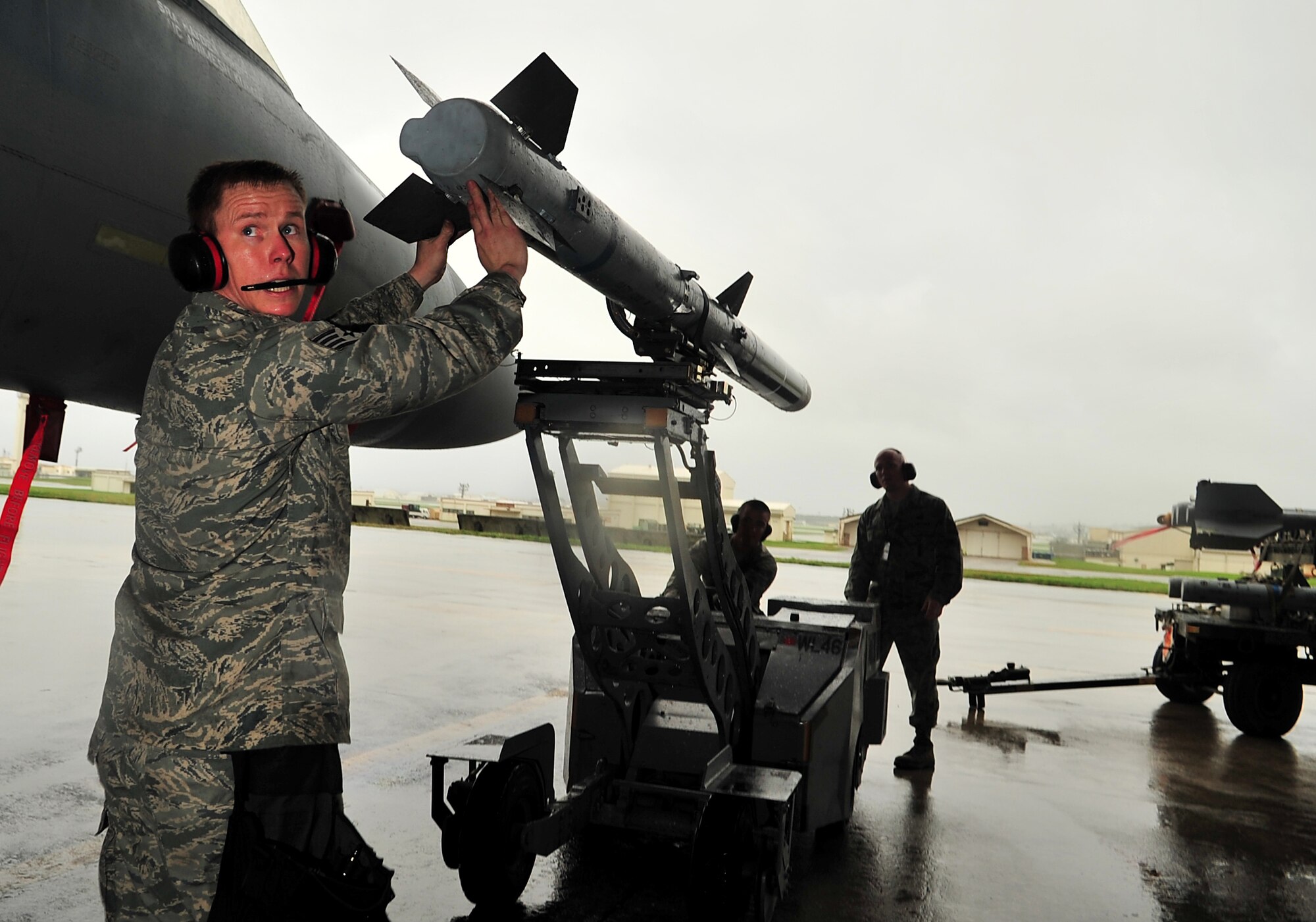 Staff Sgt. Michael Clark, 18th Aircraft Maintenance Squadron weapons crew chief, guides an AIM-9 missile to attach it to an F-15 Eagle during the Turkey Shoot 2010 at Kadena Air Base, Japan, March 9. The Turkey Shoot is an annual internal competition intended to sharpen operational capabilities and assign bragging rights. (U.S. Air Force photo/Tech. Sgt. Rey Ramon)                         