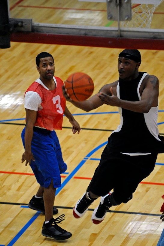 ELLSWORTH AIR FORCE BASE, S.D. -- (Right) Airman 1st Class Dan Goodson, 28th Operations Support Squadron communications security technician, attempts a layup as Senior Airman Justen Rich-Aiken, 28th Logistics Readiness Squadron vehicle maintenance technician, watches during Ellsworth's intramural basketball championship game, March 16. The 28 LRS team beat the 28 OG team, 61-58. (U.S. Air Force photo/Airman 1st Class Matthew Flynn)