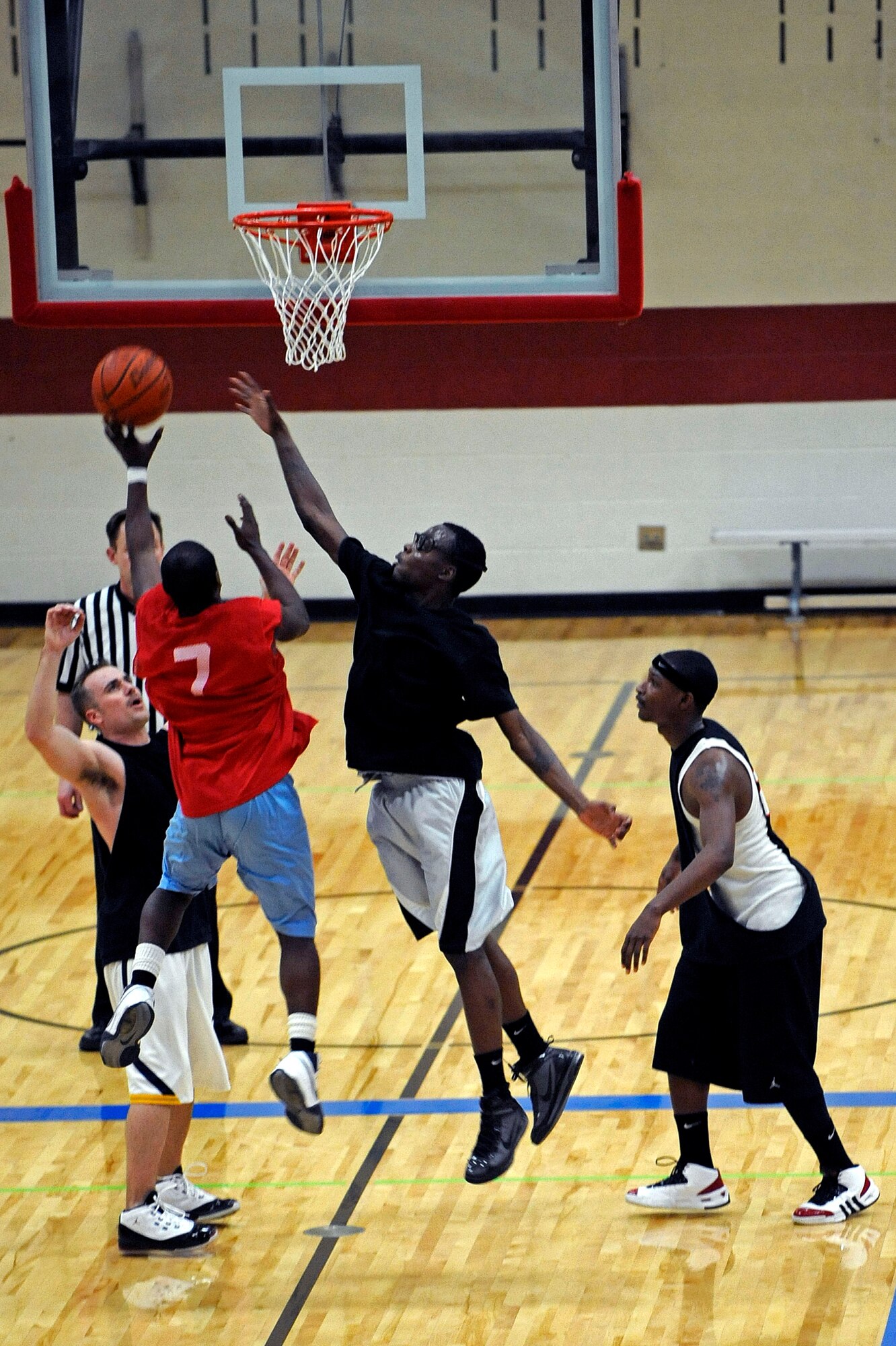 ELLSWORTH AIR FORCE BASE, S.D. -- (Center left) Airman 1st Class Brandon Bussey, 28th Logistics Readiness Squadron traffic management office journeyman, attempts a shot over members of the 28th Operations Group team during Ellsworth's intramural basketball championship game, March 16. The 28 LRS beat the 28th Operations Group, 61-58, to win the championship. (U.S. Air Force photo/Airman 1st Class Matthew Flynn)