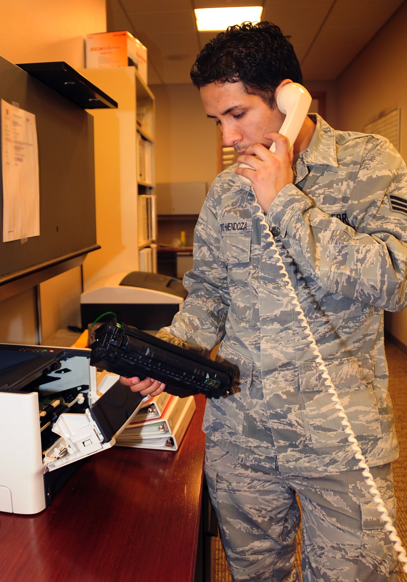 ELLSWORTH AIR FORCE BASE, S.D. -- Senior Airman Joshua Ortiz-Mendoza, 28th Mission Support Group client systems technician, speaks to Senior Airman Santos Rodriguez, 28 MSG client systems technician, over the phone to troubleshoot a faulty printer located in the 37th Bomb Squadron, March 16.  As part of his CST duties, Airman Ortiz-Mendoza performed several diagnostic tests on the printer, concluding it needed to be replaced. U.S. Air Force photo/Airman 1st Class Anthony Sanchelli)
