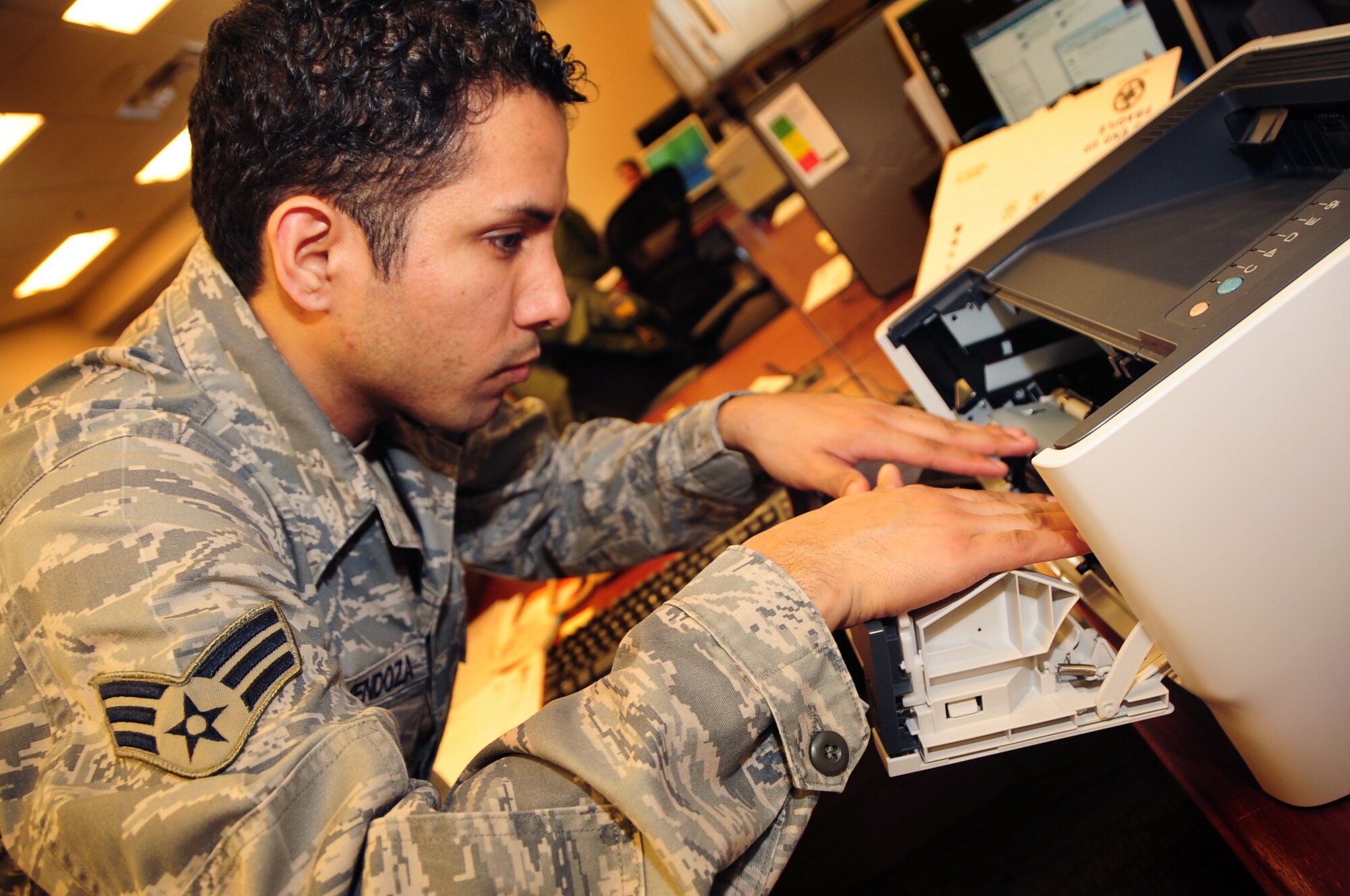 ELLSWORTH AIR FORCE BASE, S.D. -- Senior Airman Joshua Ortiz-Mendoza, 28th Mission Support Group client systems technician, checks the inner components on a printer at the 37th Bomb Squadron, March 16.  Airman Ortiz-Mendoza checked all aspects of the printer in order to properly diagnosis the problem. U.S. Air Force photo/Airman 1st Class Anthony Sanchelli)
